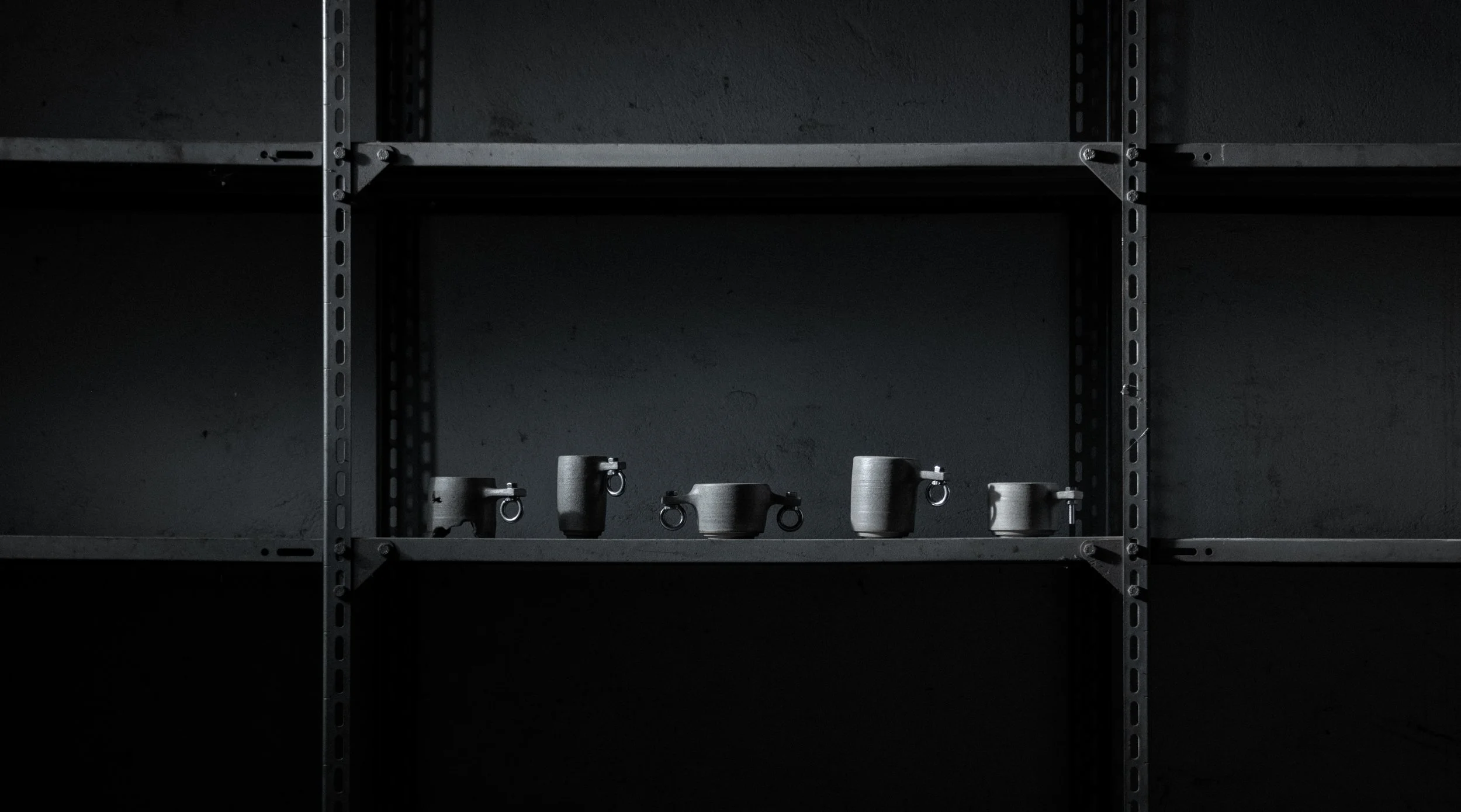 row of handmade brutalist stoneware cups on industrial steel shelving, Tea & Vinyl Berlin collection