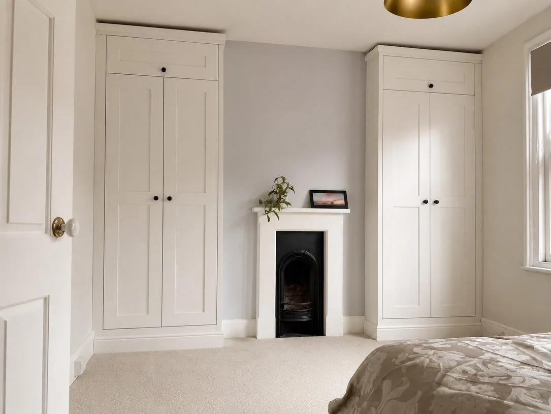 Designed around the room, built for the way it&rsquo;s used.

These bespoke fitted wardrobes were handcrafted to maximise storage within the alcoves while framing the original fireplace.

With a combination of hanging space, shelving and overhead sto