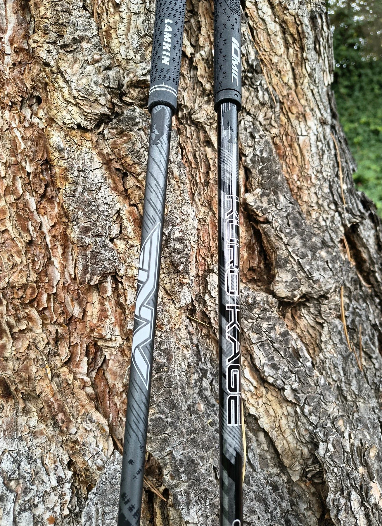 Two golf clubs with Lamkin Tour Pro grips leaning against a tree.
