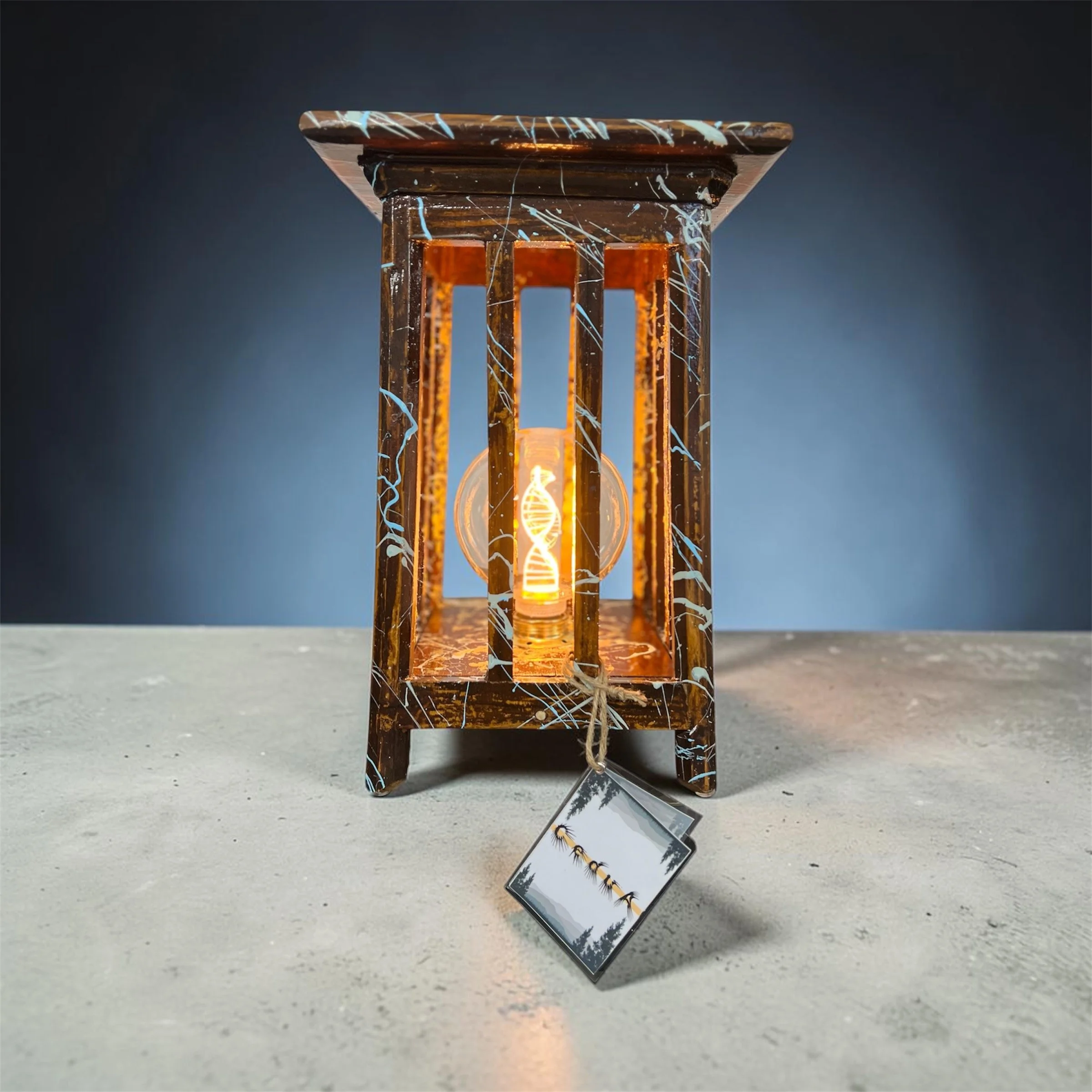 Table lamp created by combining two repurposed elements, featuring a DNA style led filament bulb and hand decorated whith an abstract design
