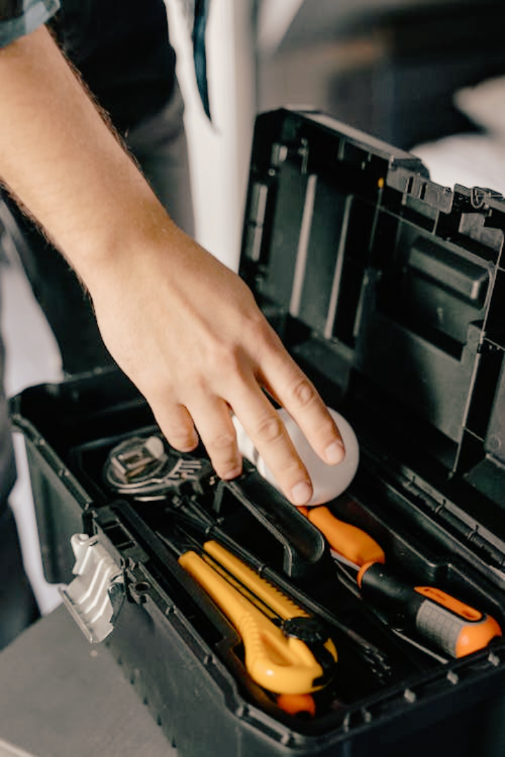 Maintenance worker reaching into their toolbox