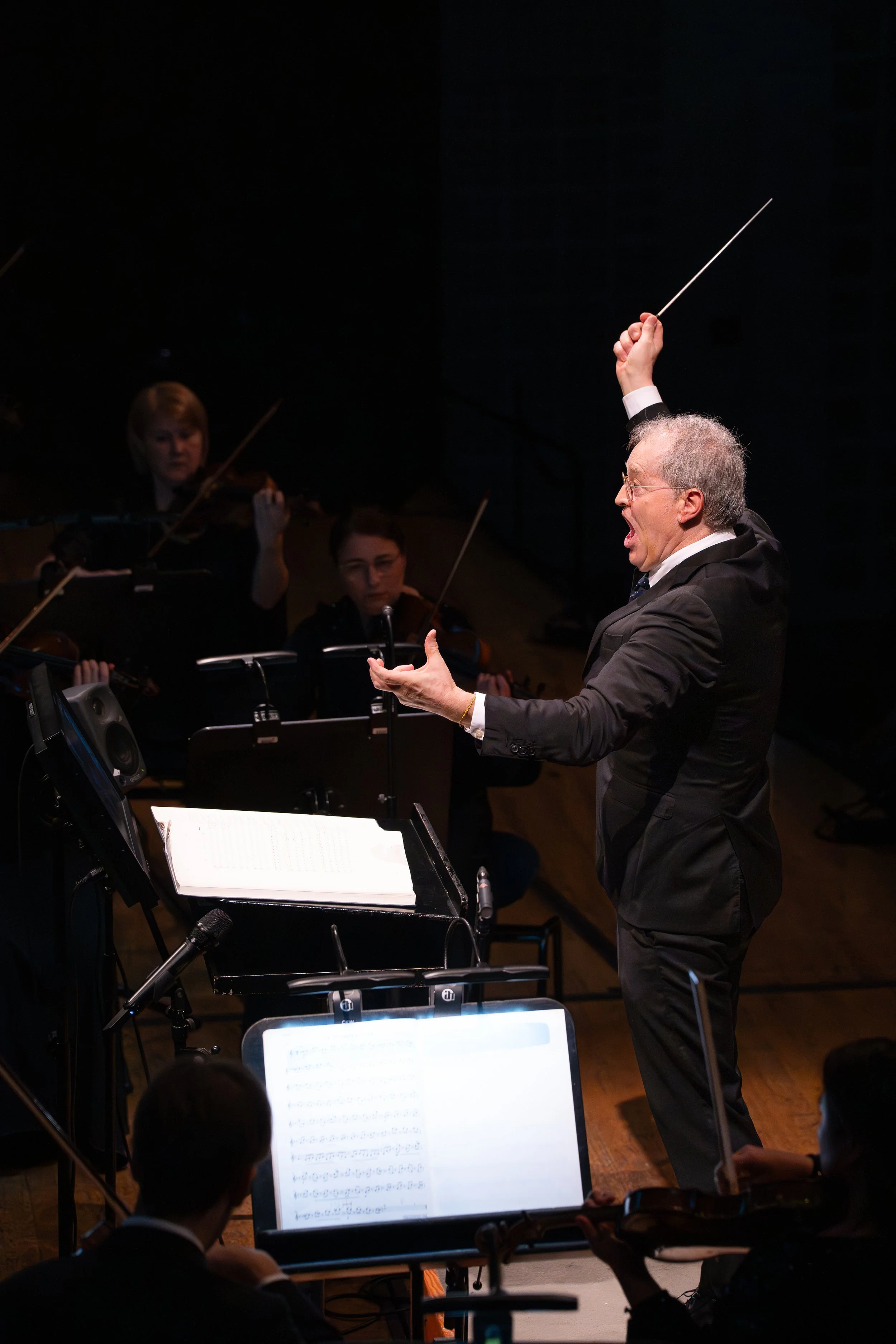 Dirigent Ludwig Wicki leitet das 21st Century Orchestra während eines Live-Konzerts im KKL Luzern mit erhobenem Taktstock und ausdrucksstarker Geste