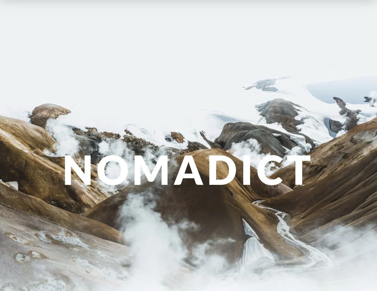 Titelbild des Nomadict Magazine mit einer beeindruckenden Vulkanlandschaft aus dampfenden Bergen, Gletschern und Flusstälern. Das Cover präsentiert die internationale Reise- und Outdoor-Publikation Nomadict