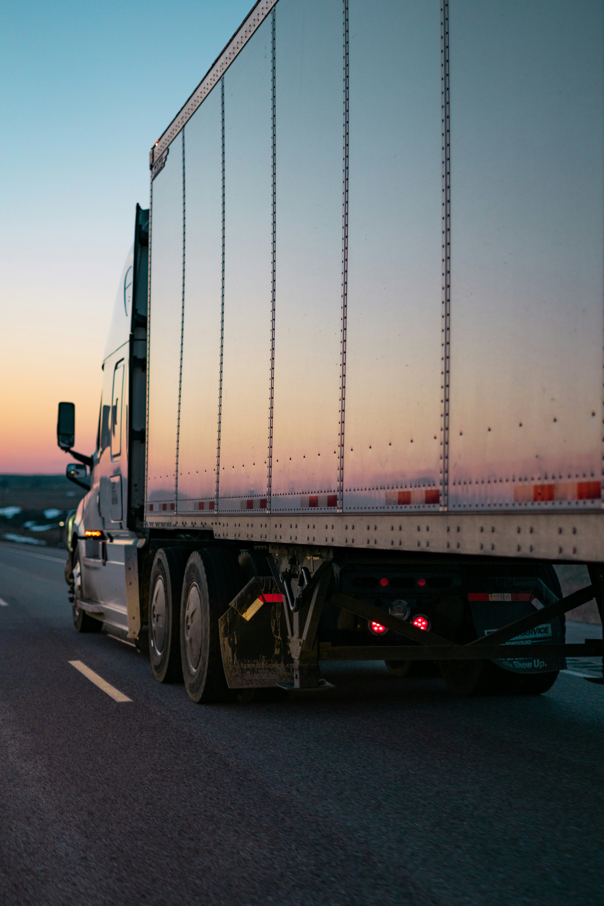 Semi truck trailer on the highway at sunset