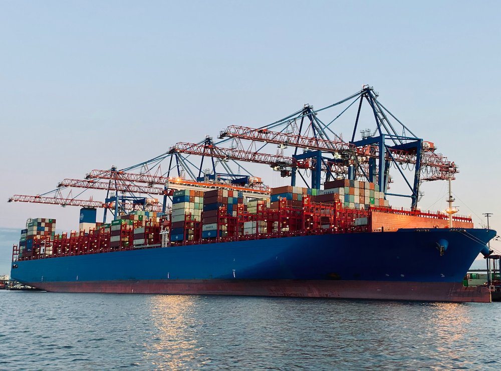Container ship being loaded by gantry cranes at port