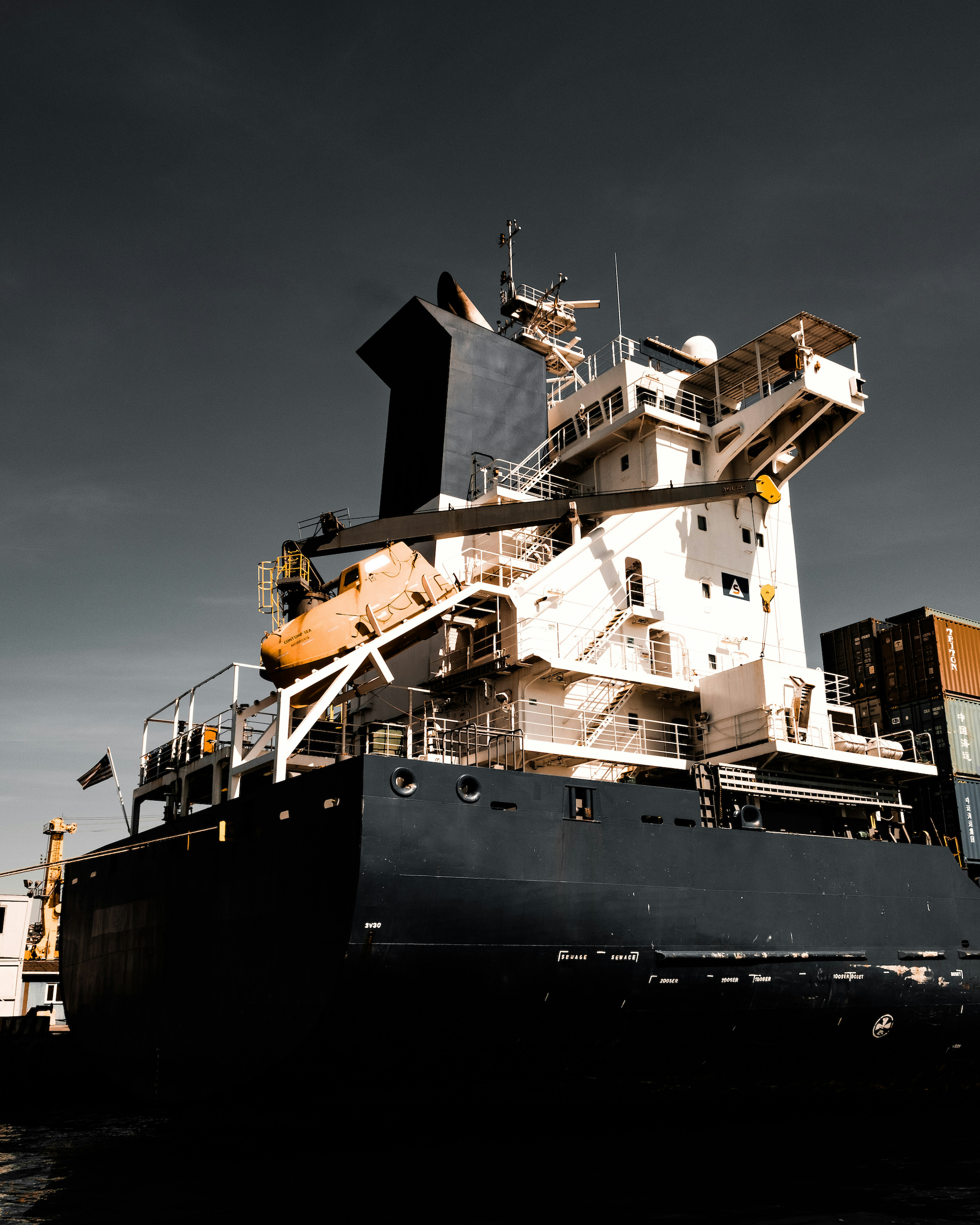 Cargo ship with crane and deck equipment docked at port