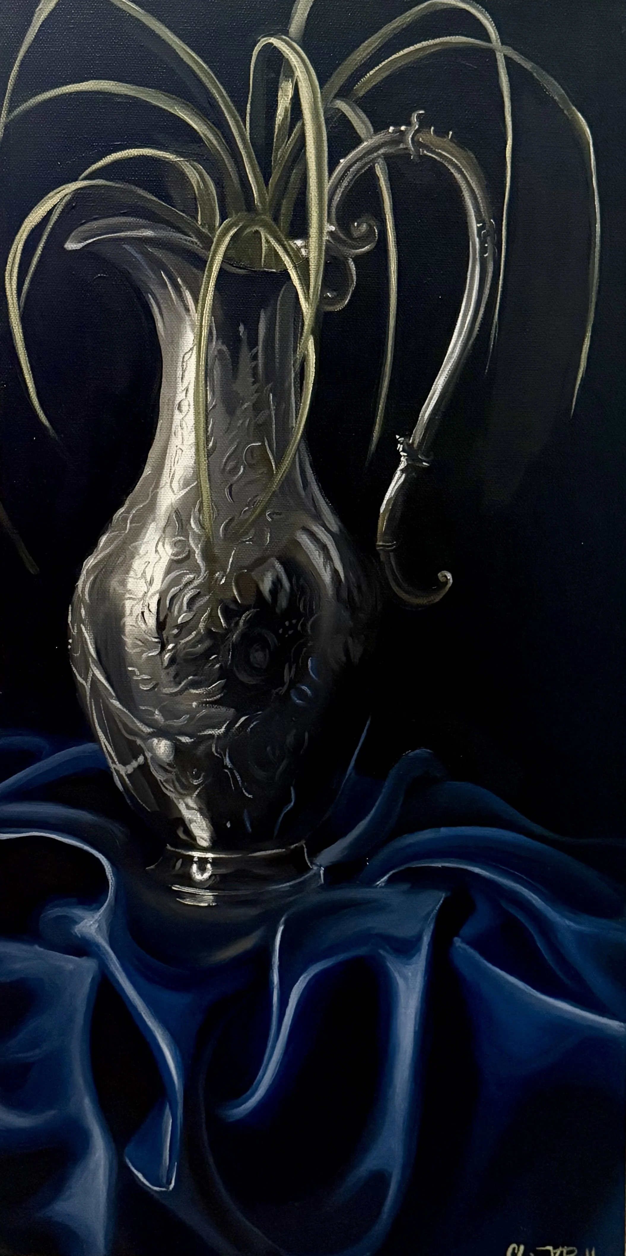 A realistic painting of an ornate silver vase with intricate engravings, filled with long green plant leaves, placed on a dark fabric background.