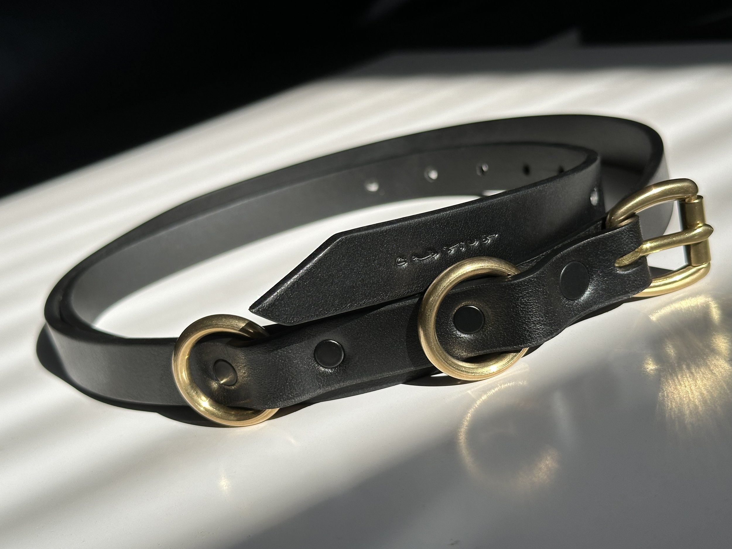 Cassius_slim classic belt_black brass_impact shot.jpg