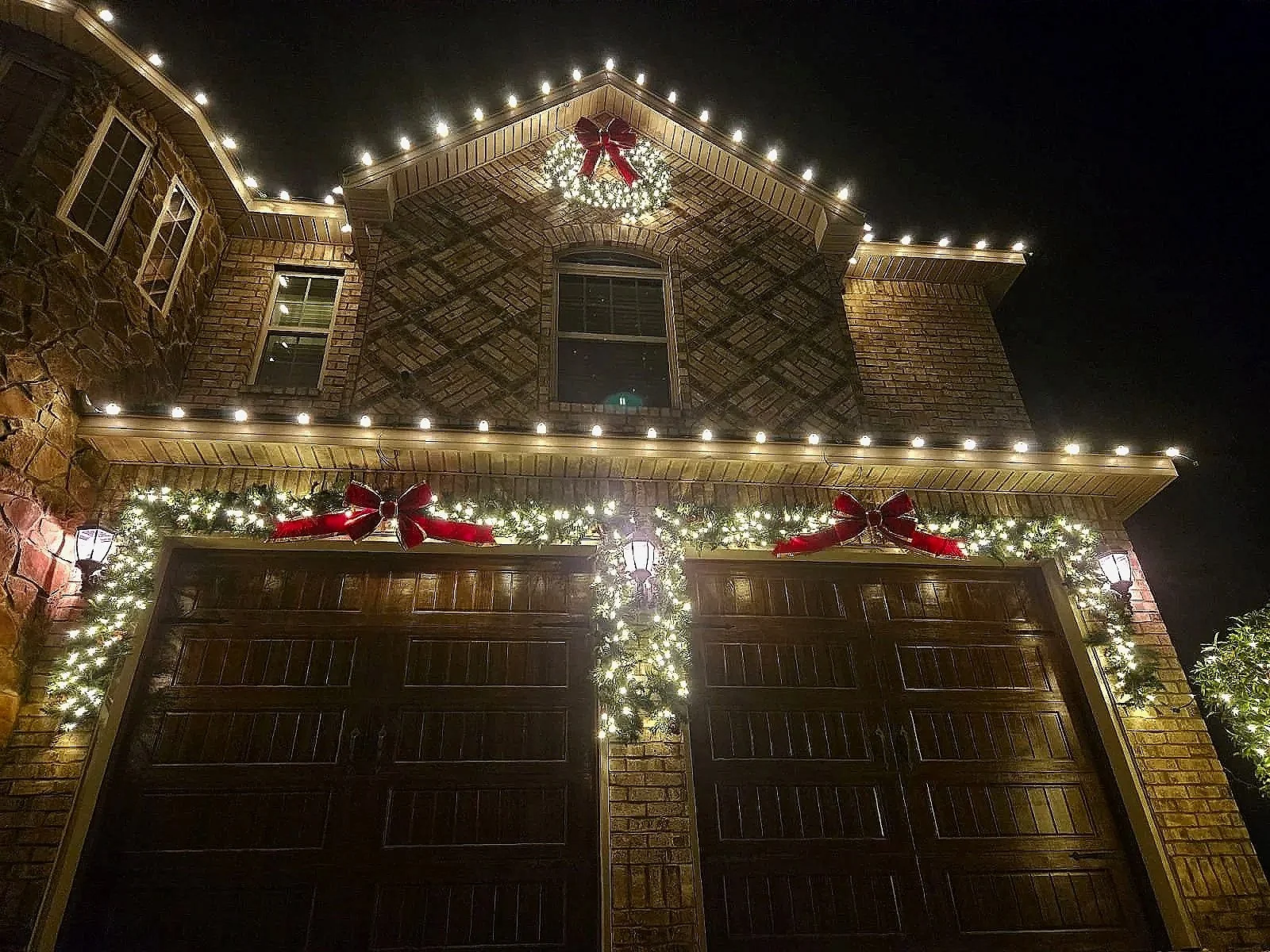 Bright LED holiday tree wrapping and landscape lighting for a residence in Milledgeville.