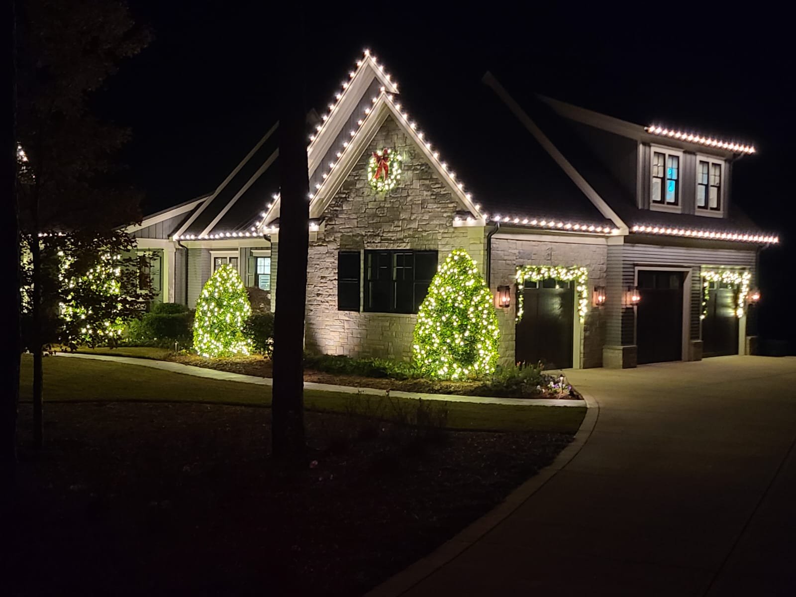 Professional holiday lighting with custom-cut rooflines and lit garland in Eatonton, Georgia.