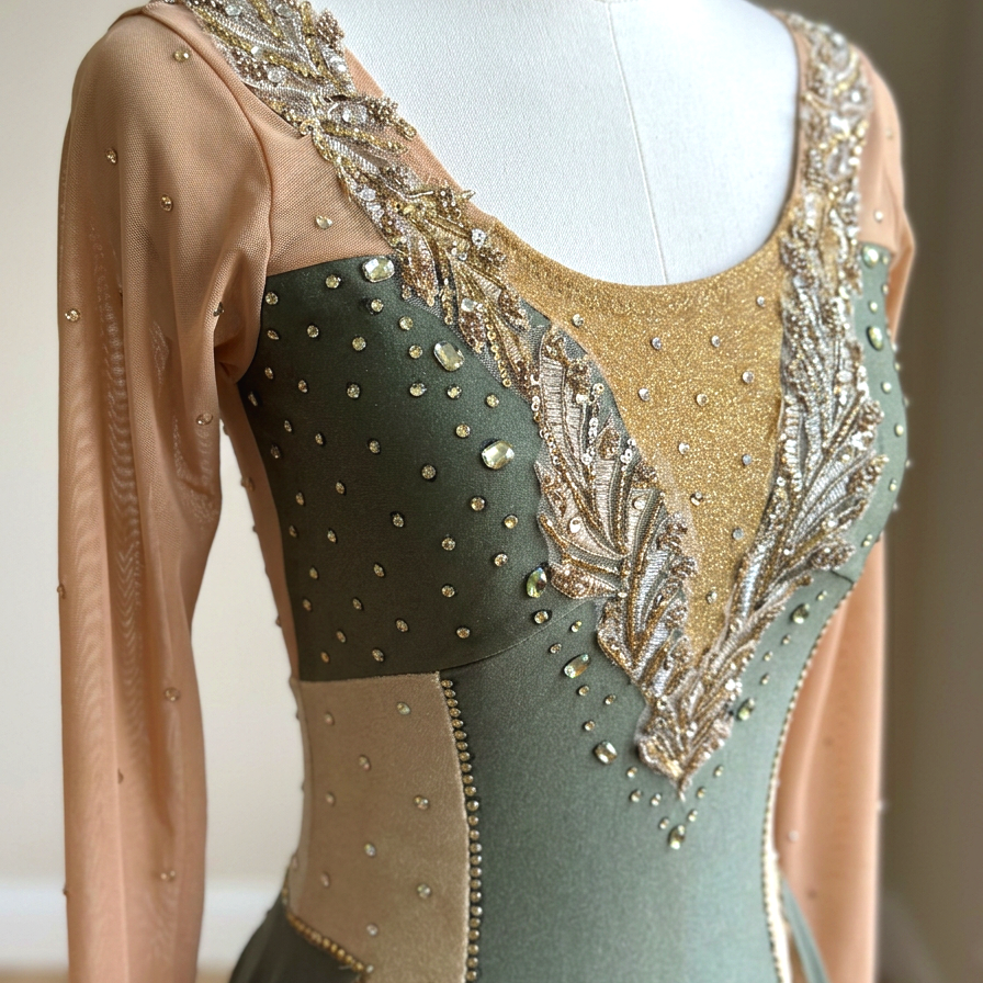 Close-up of an ornate dance costume with gold, green, and nude fabric, decorated with sequins, beads, and embroidery.