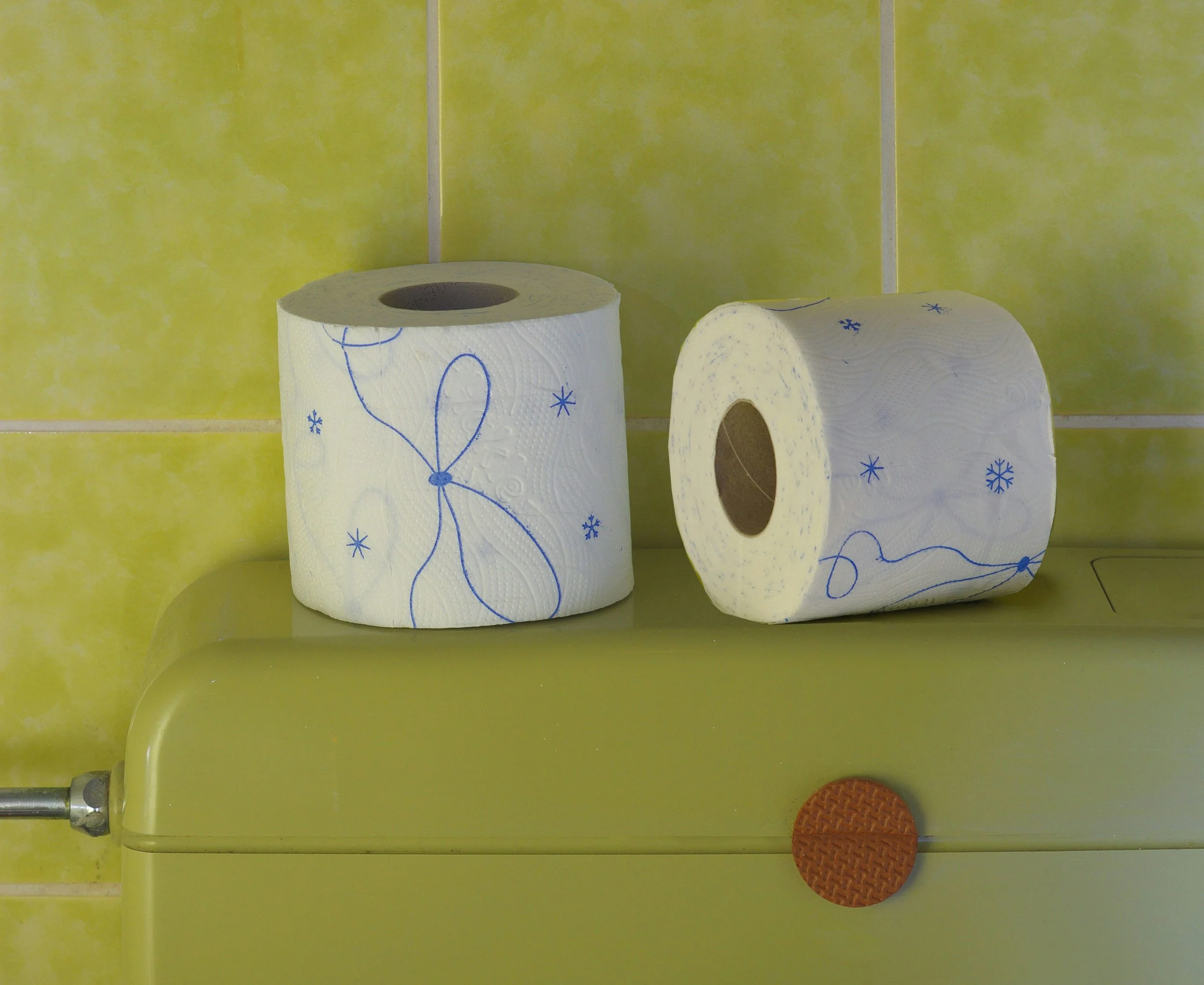 Rouleaux de papier toilette placés sur une surface jaune, symbolisant le transit intestinal.