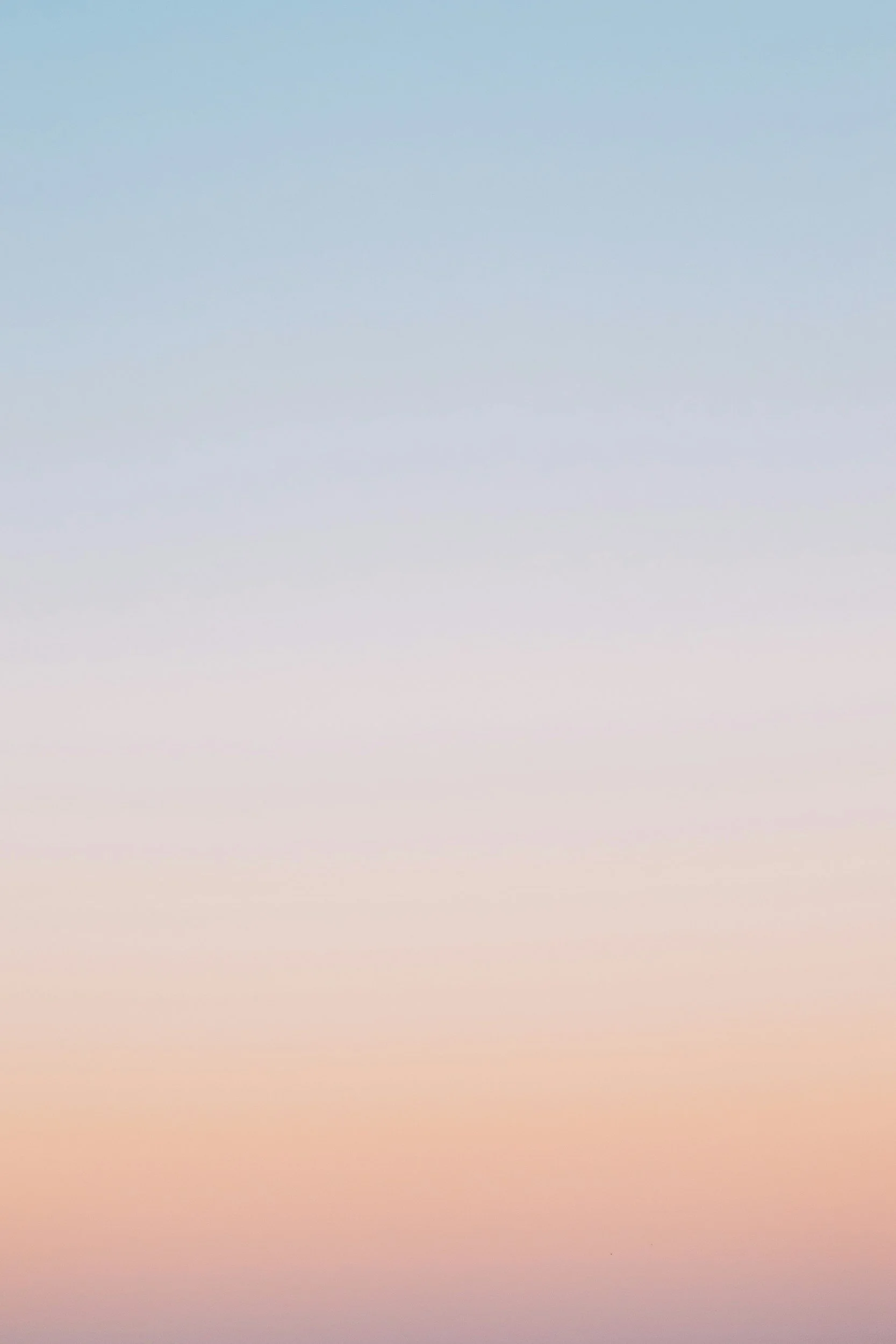 A clear sky with a gradient of pastel colors from blue to pink and orange near the horizon.