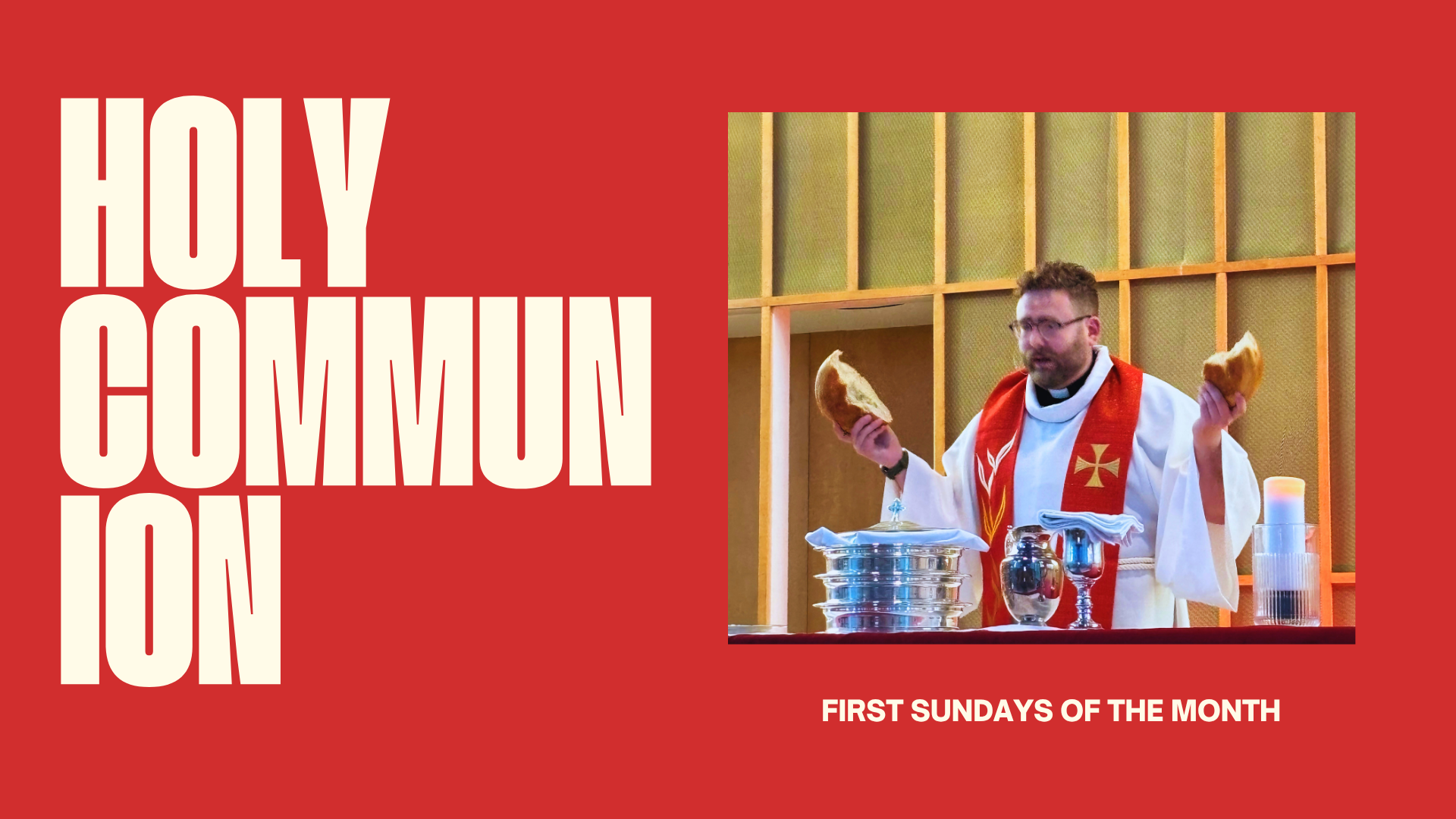 A priest dressed in white robes with a red stole, holding pieces of bread in both hands during a religious service, standing behind a table with chalice and other items, with a background of wooden wall panels.