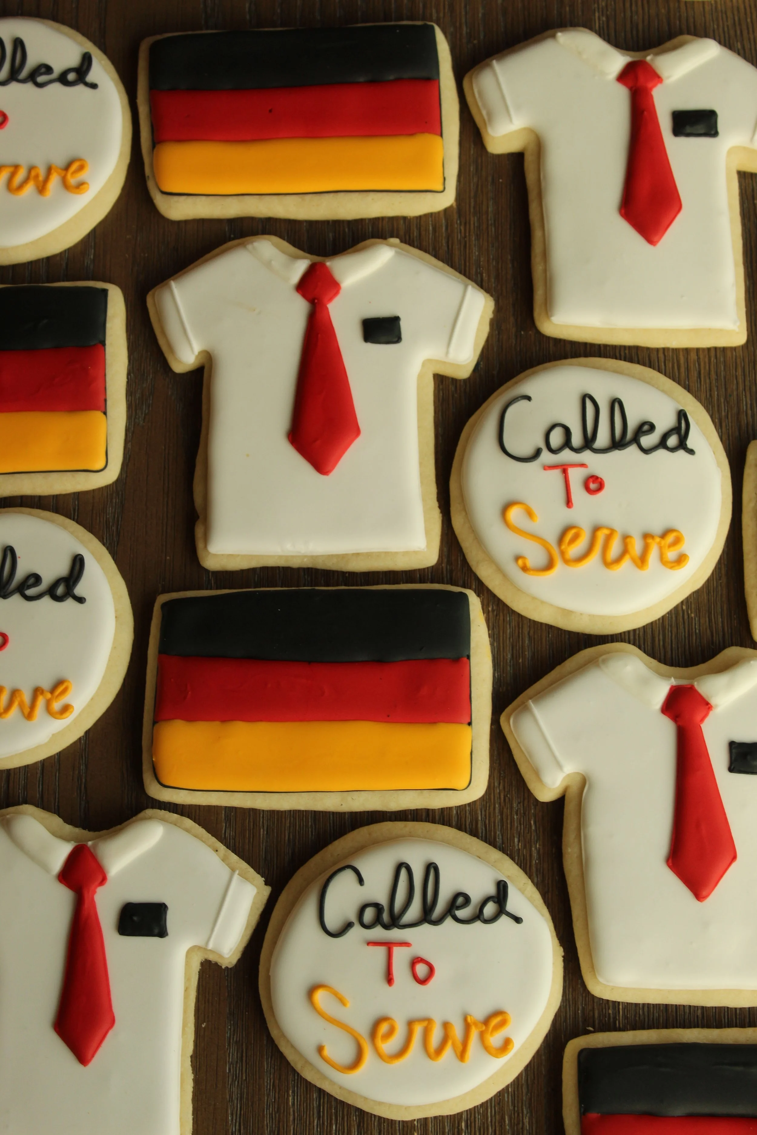 Cookies decorated with a missionary uniform theme, featuring white shirts with red ties, black name tags, and a German flag.