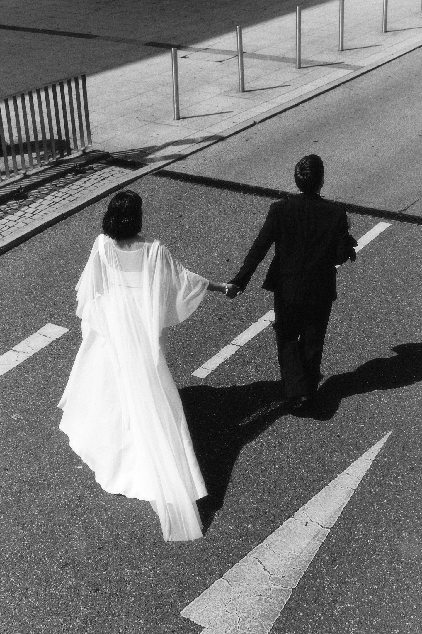 Brautpaar geht Hand in Hand durch die Stuttgarter Innenstadt vor seiner Hochzeitsfeier im Hallo Emil, fotografiert in Schwarz-Weiß.
