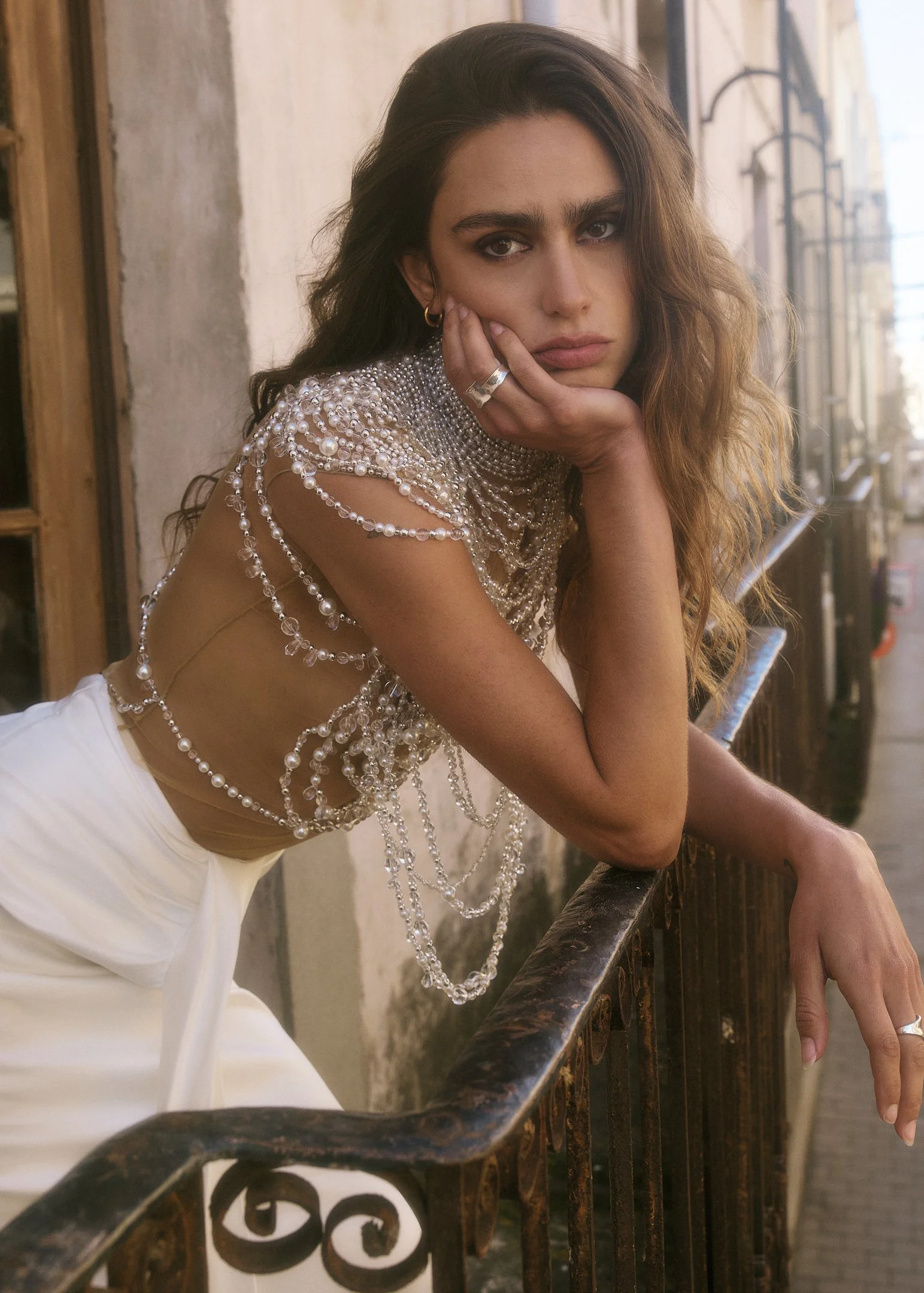 Bridal portrait of Elena leaning on a wrought-iron balcony in a Catalan town near Barcelona.