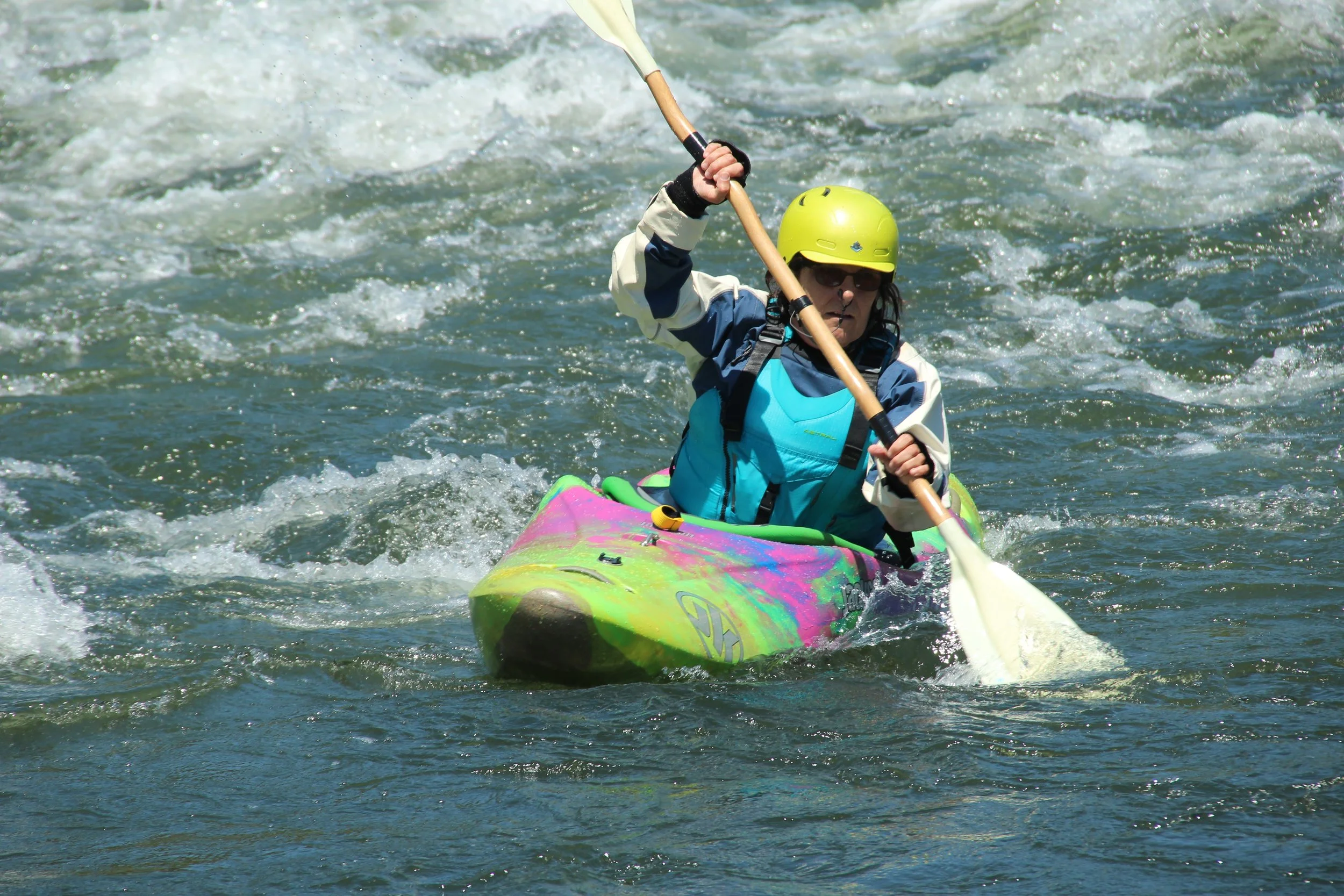 A picture of Marguerite Young kayaking on rapids, a favorite hobby of hers.