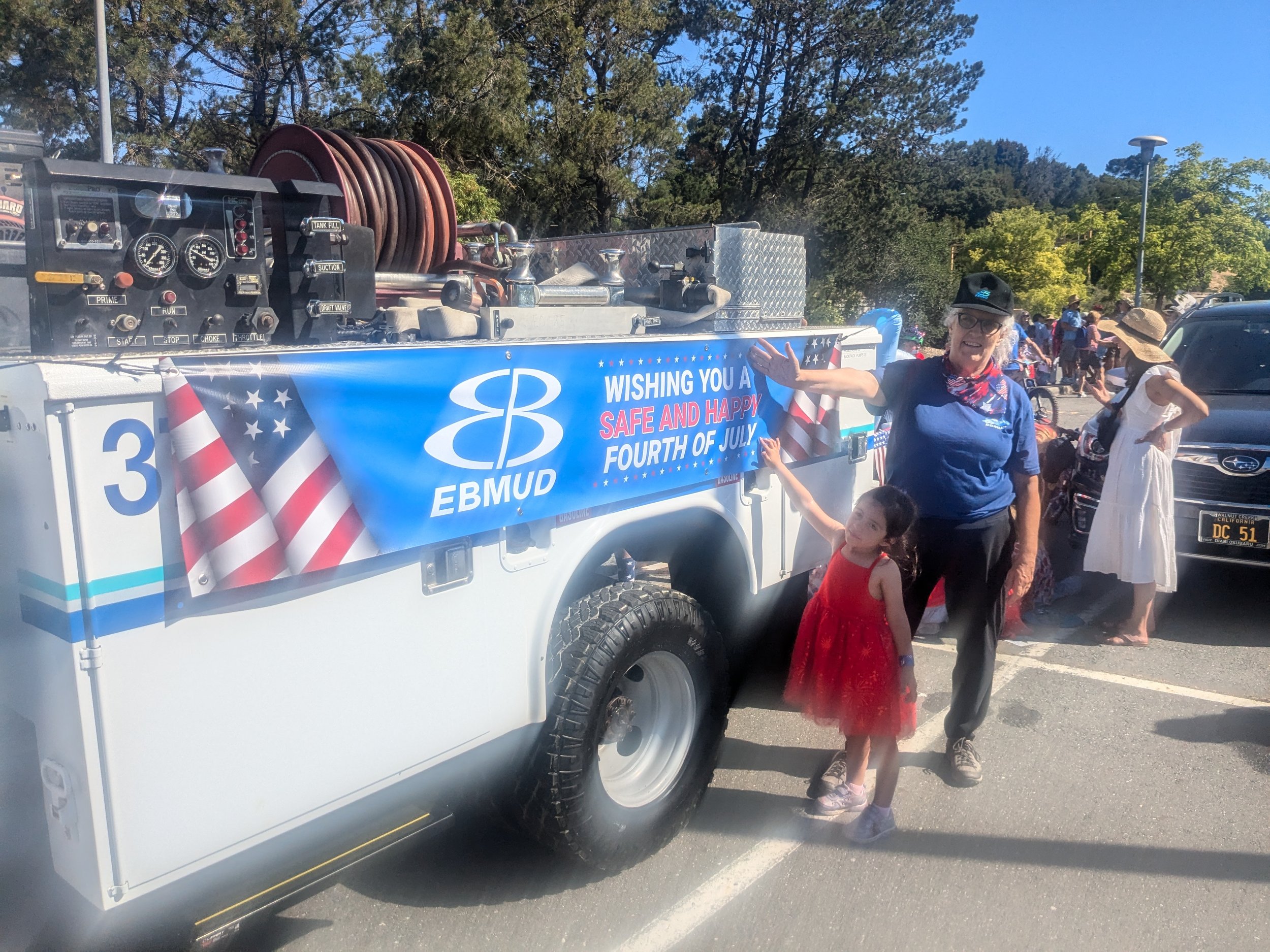 Marguerite with her grandaugher Rhea, pictured in front of an EBMUD Truck decorated for the Orinda July 4th parade.