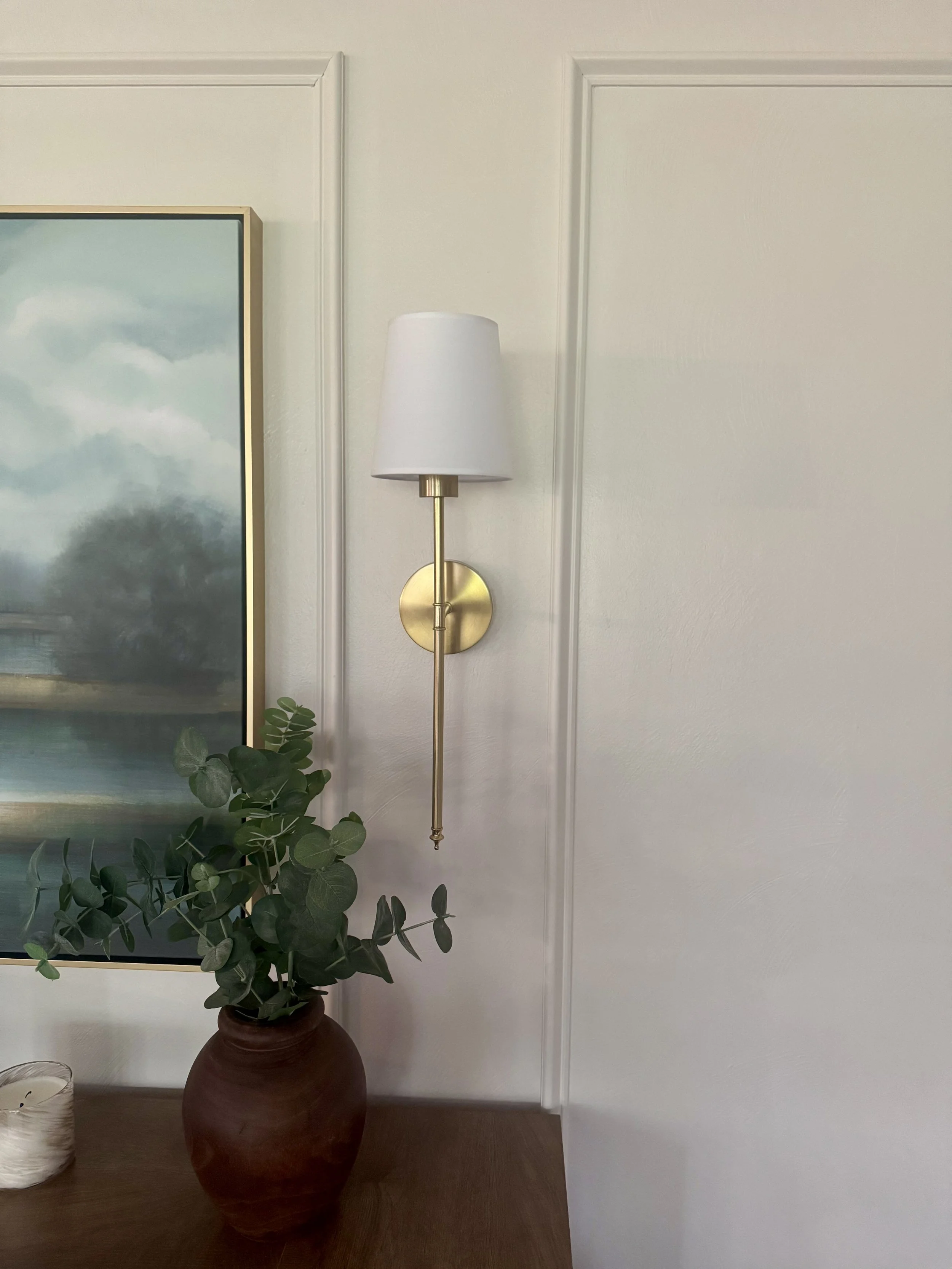Brass Wall Sconces,
The brass sconces add another layer of warm light while framing the artwork and giving the wall a more finished, architectural feel.
Shop the wall sconces →