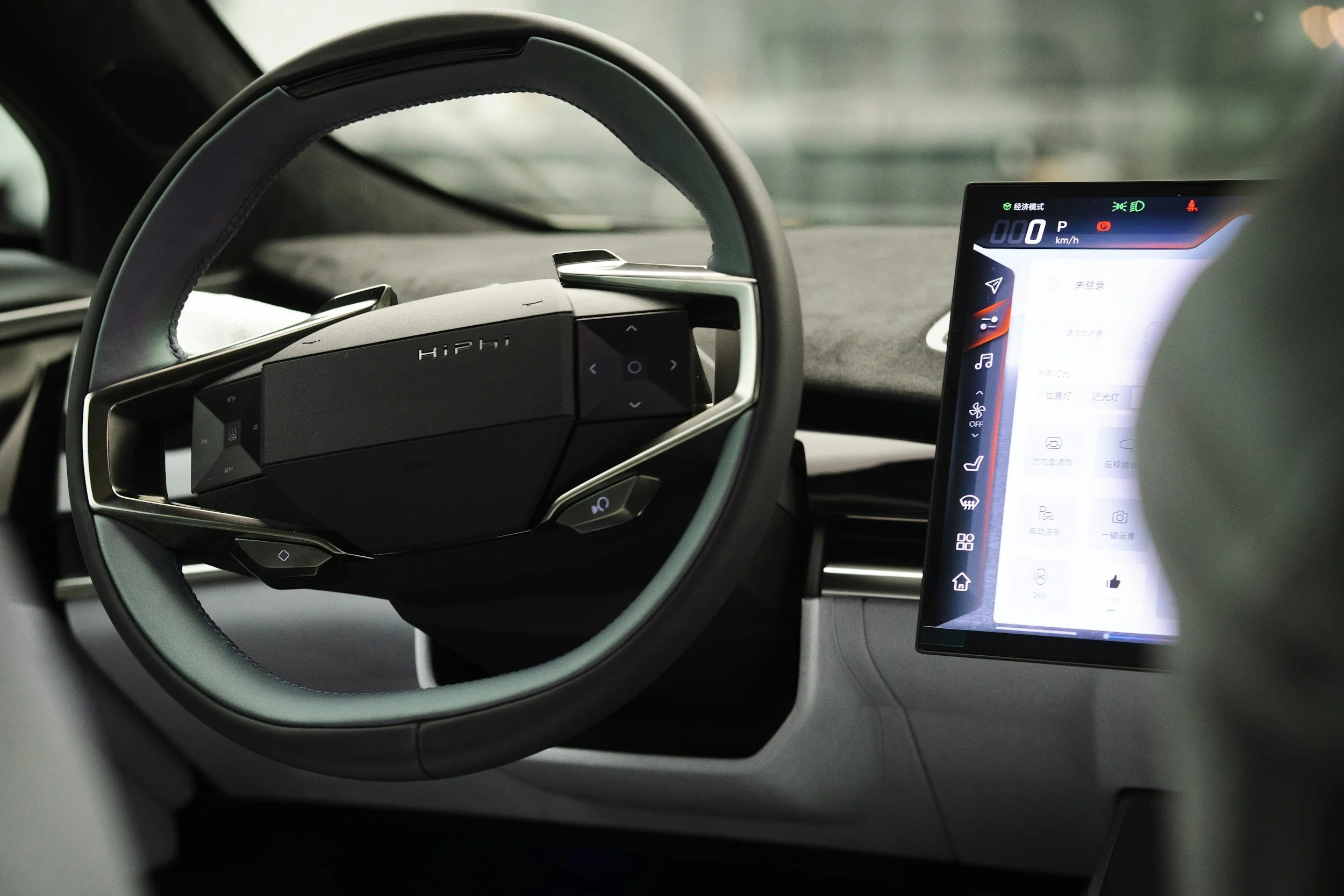 Interior of a modern car showing the steering wheel and a digital dashboard display screen.