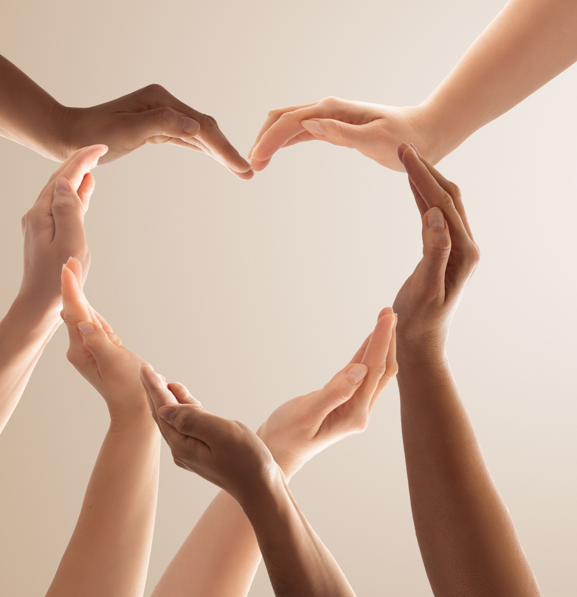 Multiple hands of diverse skin tones reaching towards each other, forming a heart shape in the center.