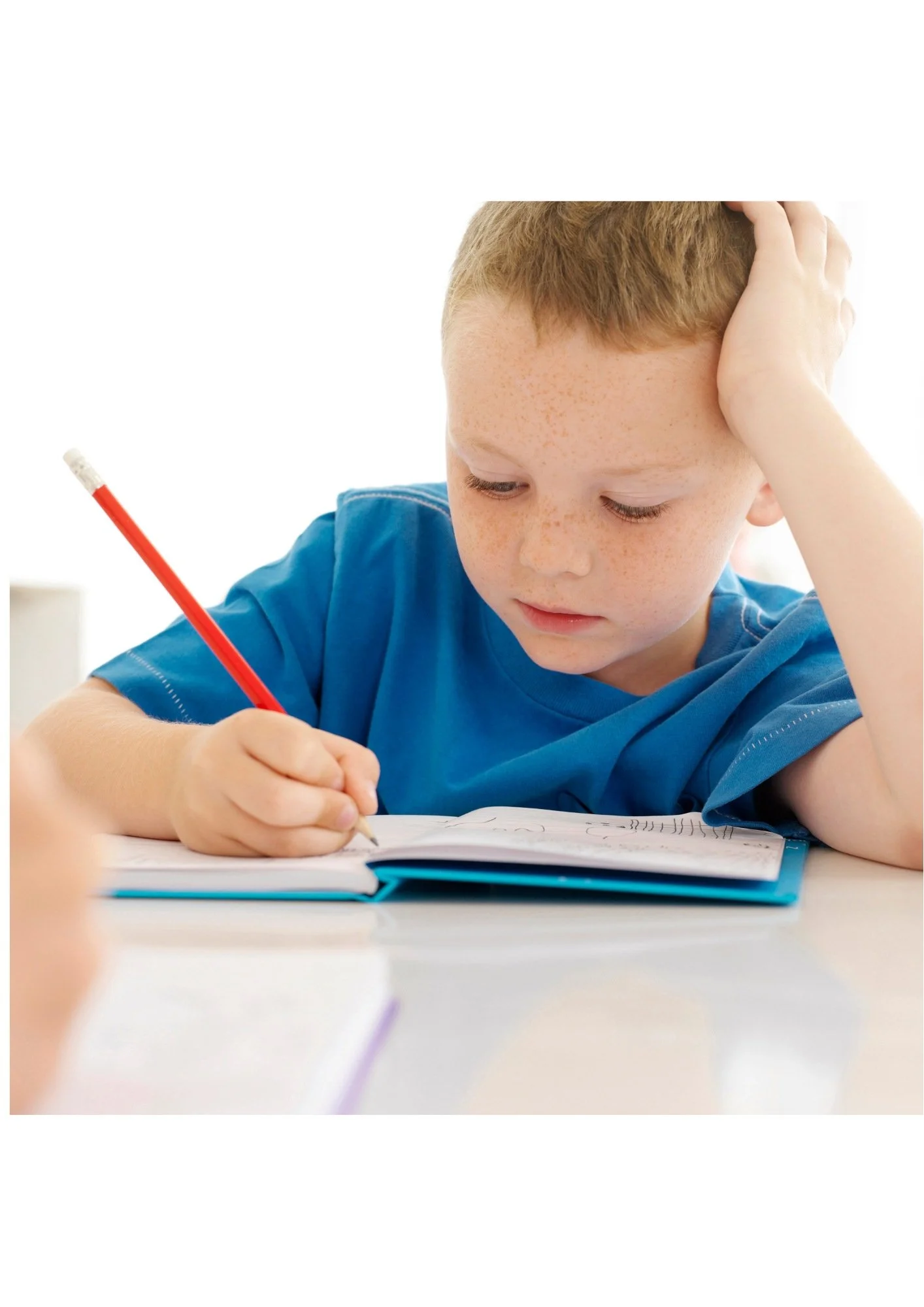 boy using pencil to write in notebook