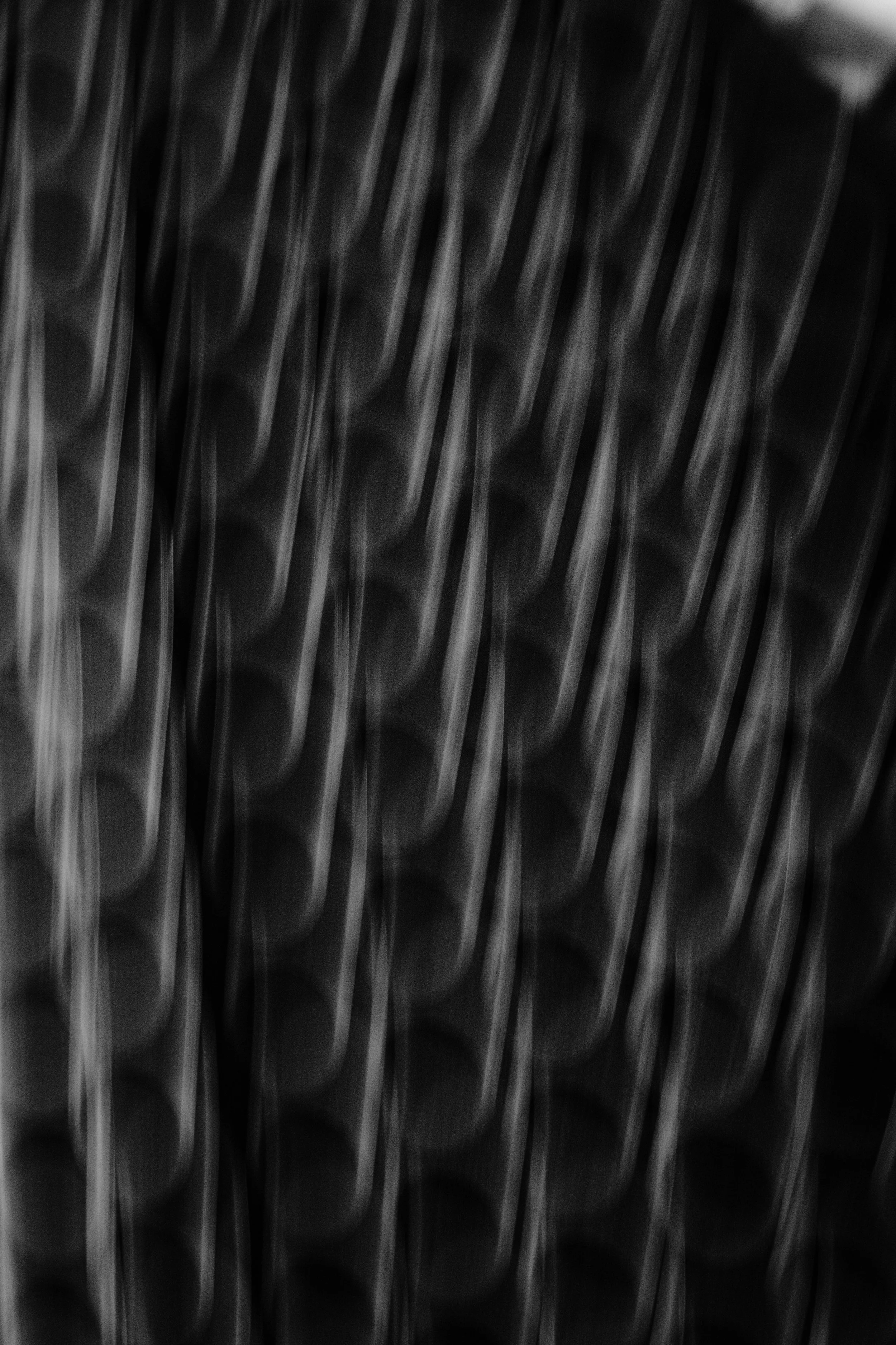 Close-up of a metallic surface with vertical lines and a textured pattern.