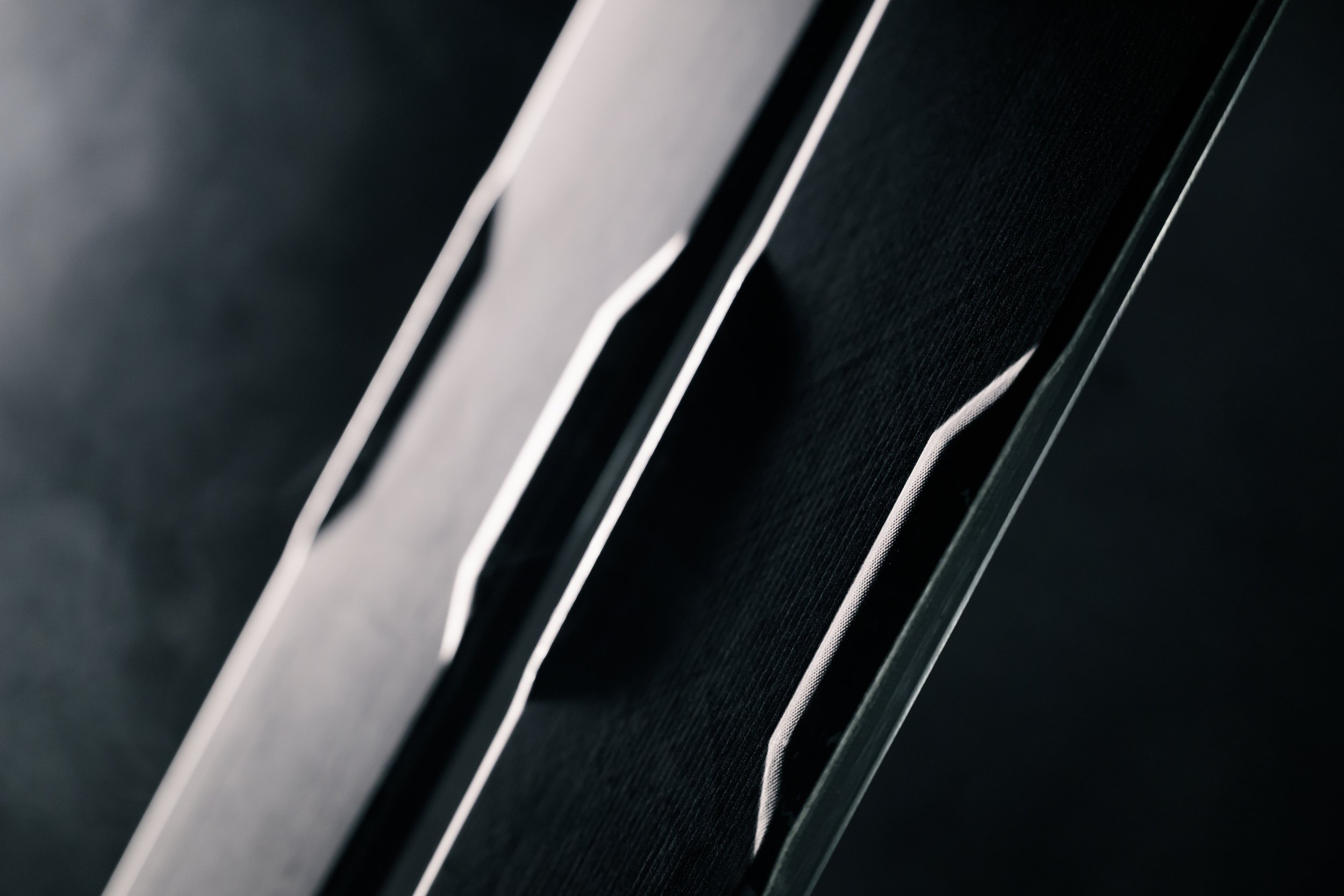 Close-up of a modern electronic device, possibly a speaker or audio equipment, with sleek black and metallic accents.