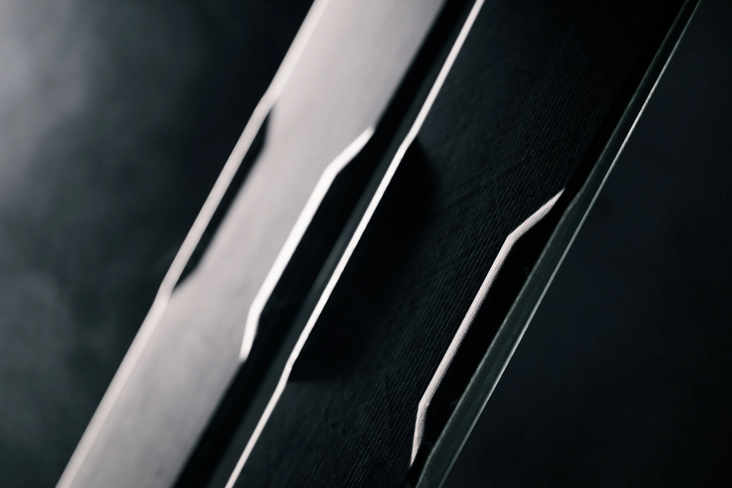 Close-up of a speaker with black fabric and silver accents.
