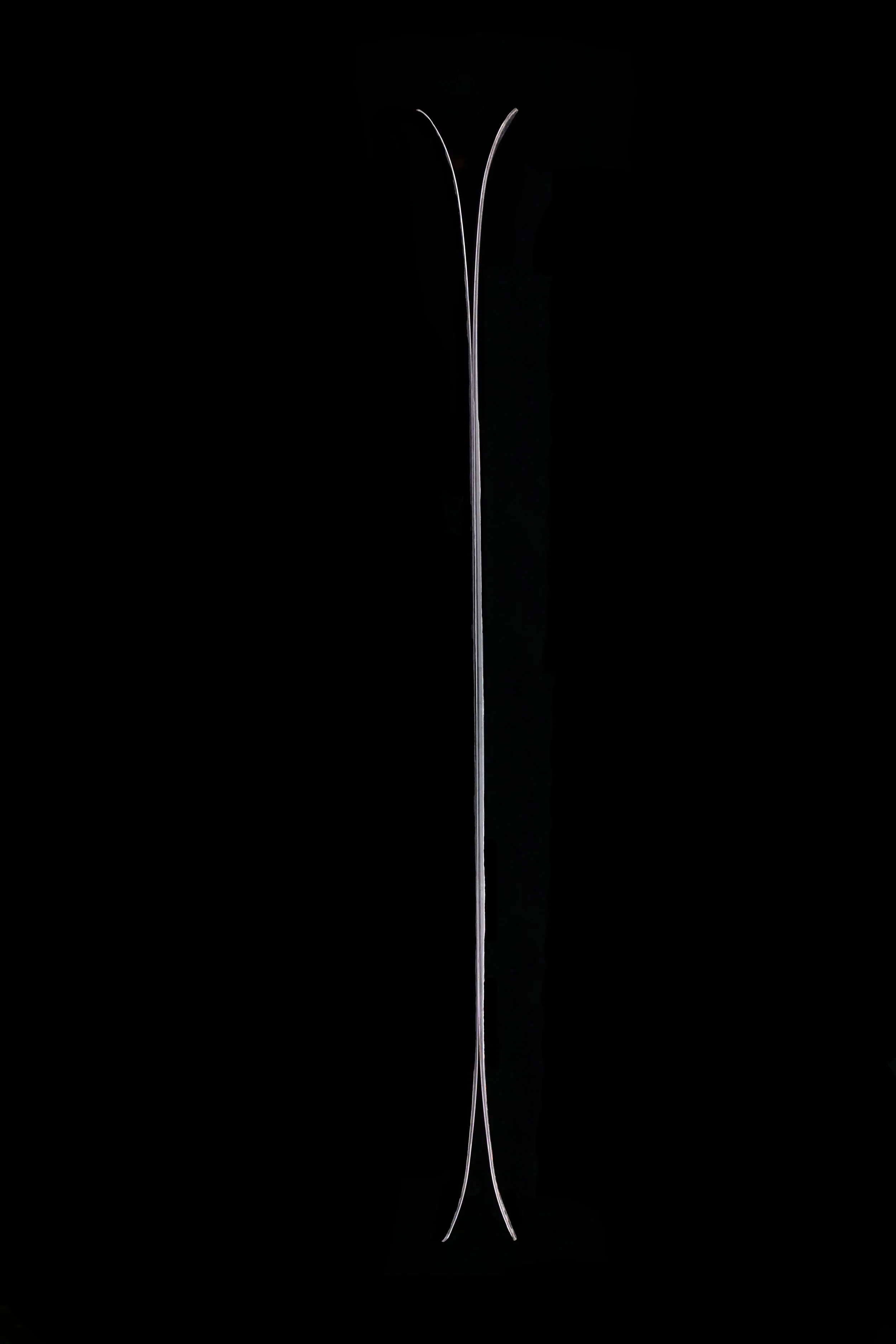 Close-up of a single, thin, metallic needle against a black background.