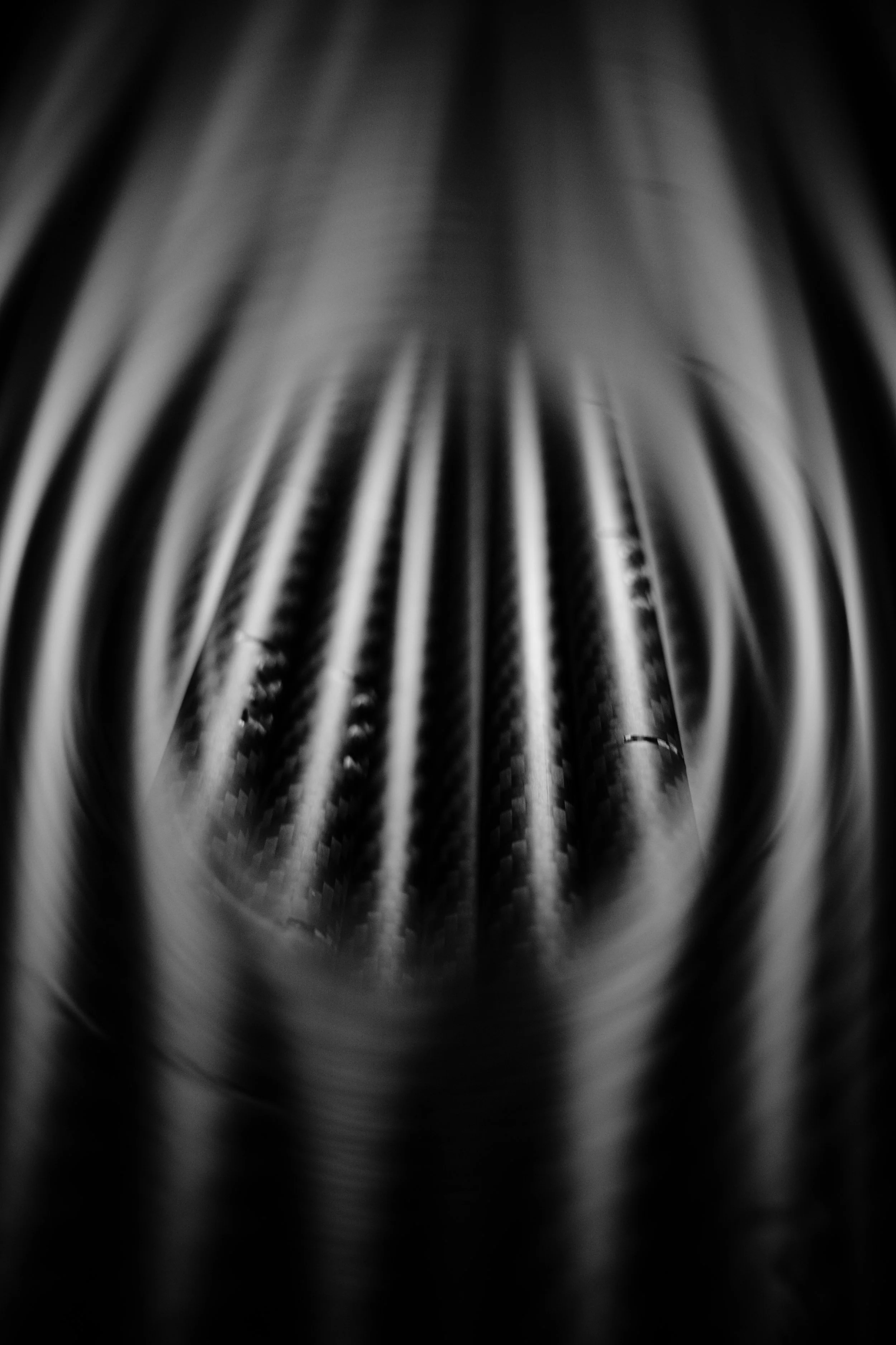 Close-up of metal ridges or fins, possibly part of a machine or industrial equipment, in black and white.