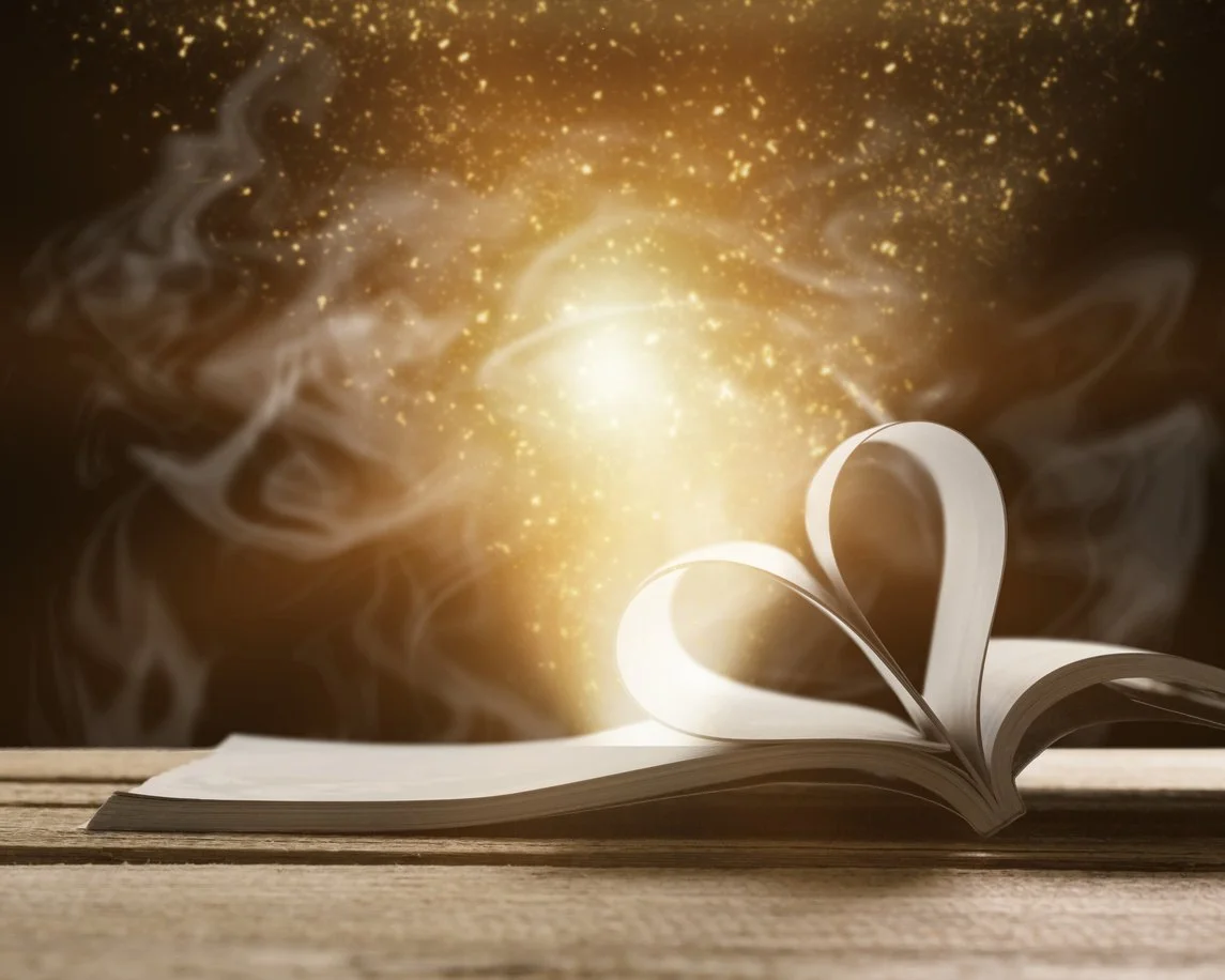 Book open on a table with magical lights and smoke coming out of its pages. Two of the pages have been folded to form a heart.