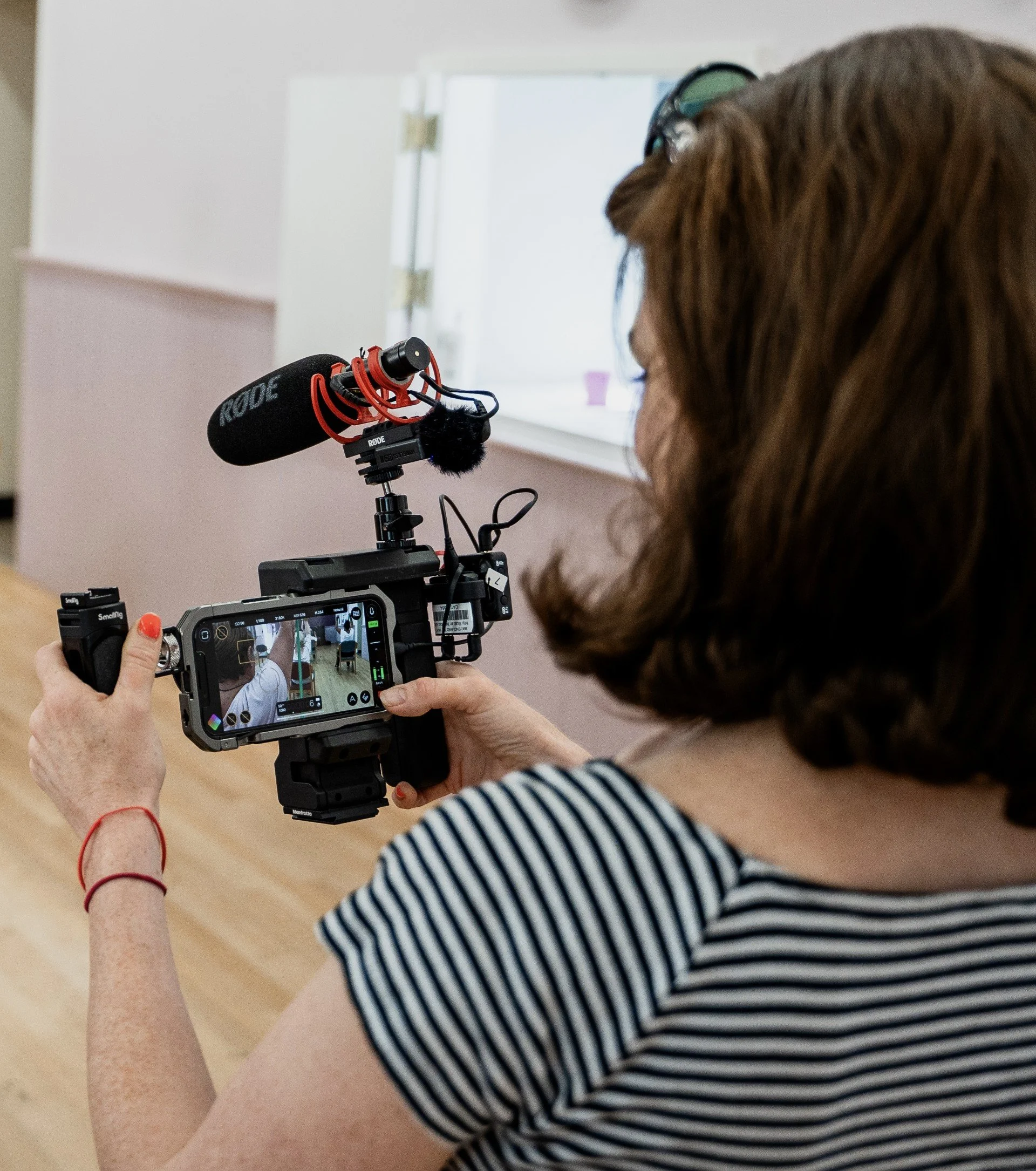 A person holding a professional camera with a mounted microphone for Media Training and Podcast Training