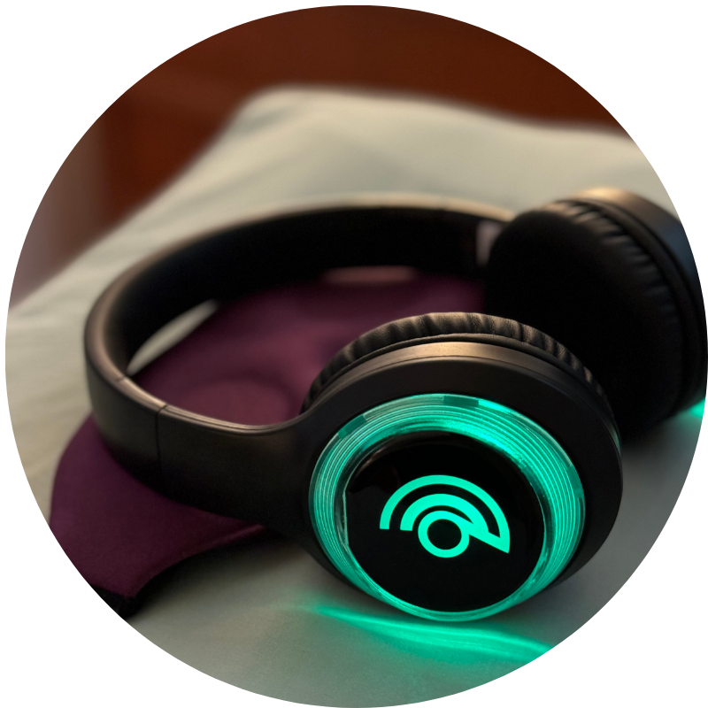 A pair of black 9D Breathwork headphones with a glowing green logo on the side.