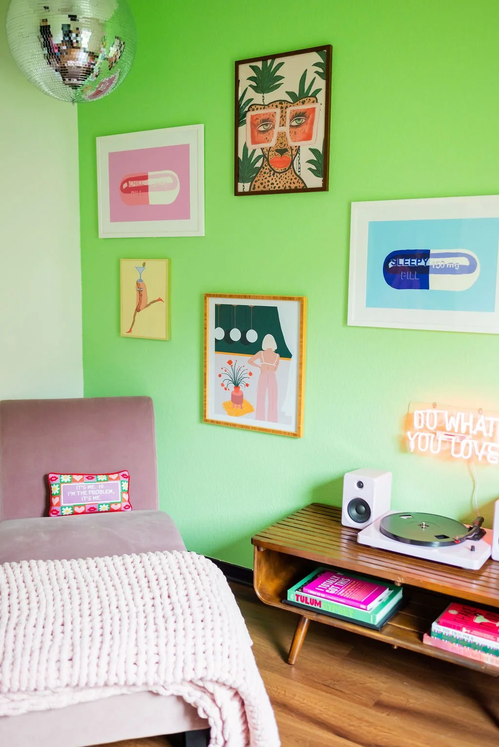 Colorful therapy office designed for adults and college students seeking virtual counseling in Texas, with a green accent wall, vibrant artwork, disco ball, record player, and cozy pink chair.