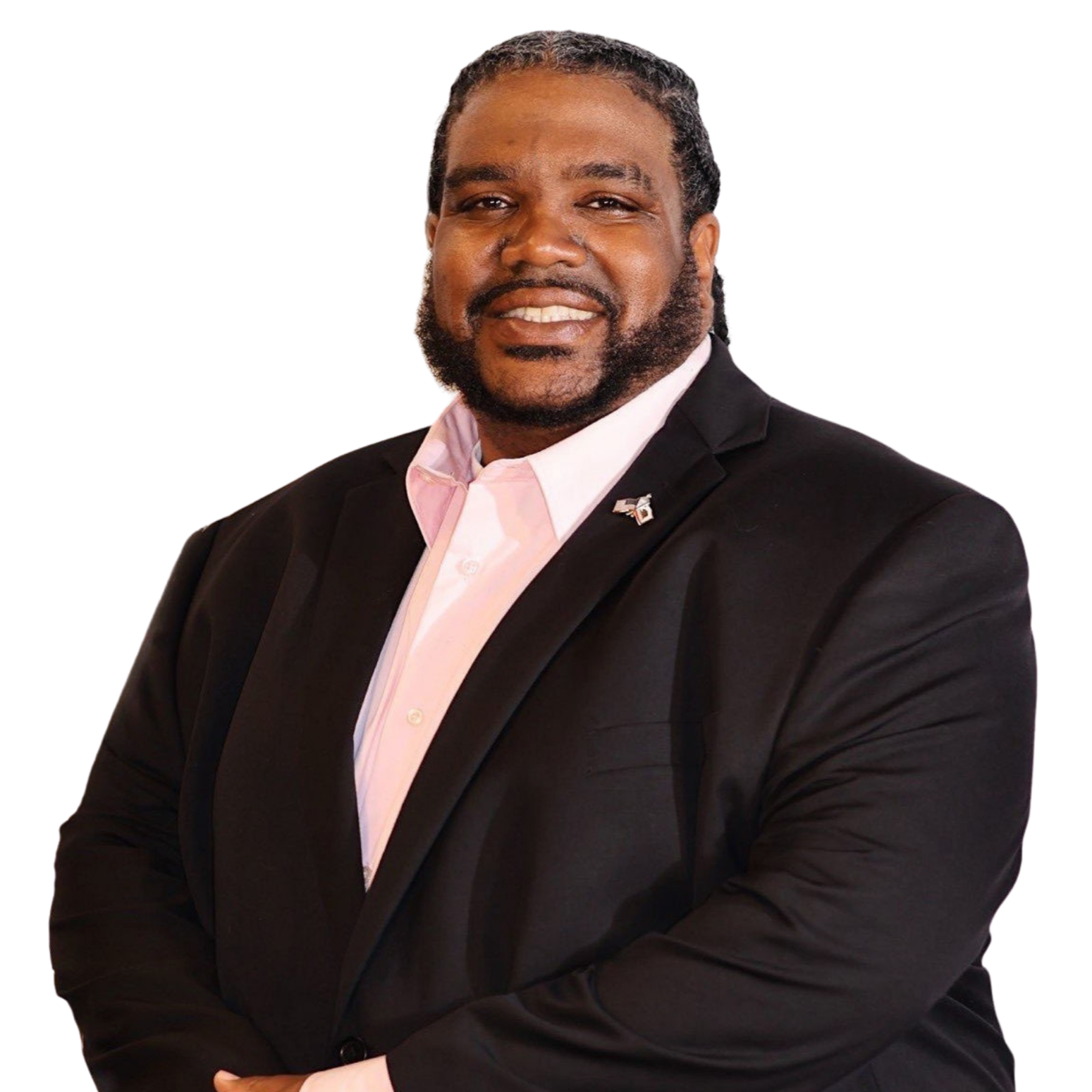 A photo of Brandon Dawkins, candidate for Antioch School Board, wearing a black suit jacket, button-down shirt, and a pin of the American and California flags on his lapel, posed with arms crossed.