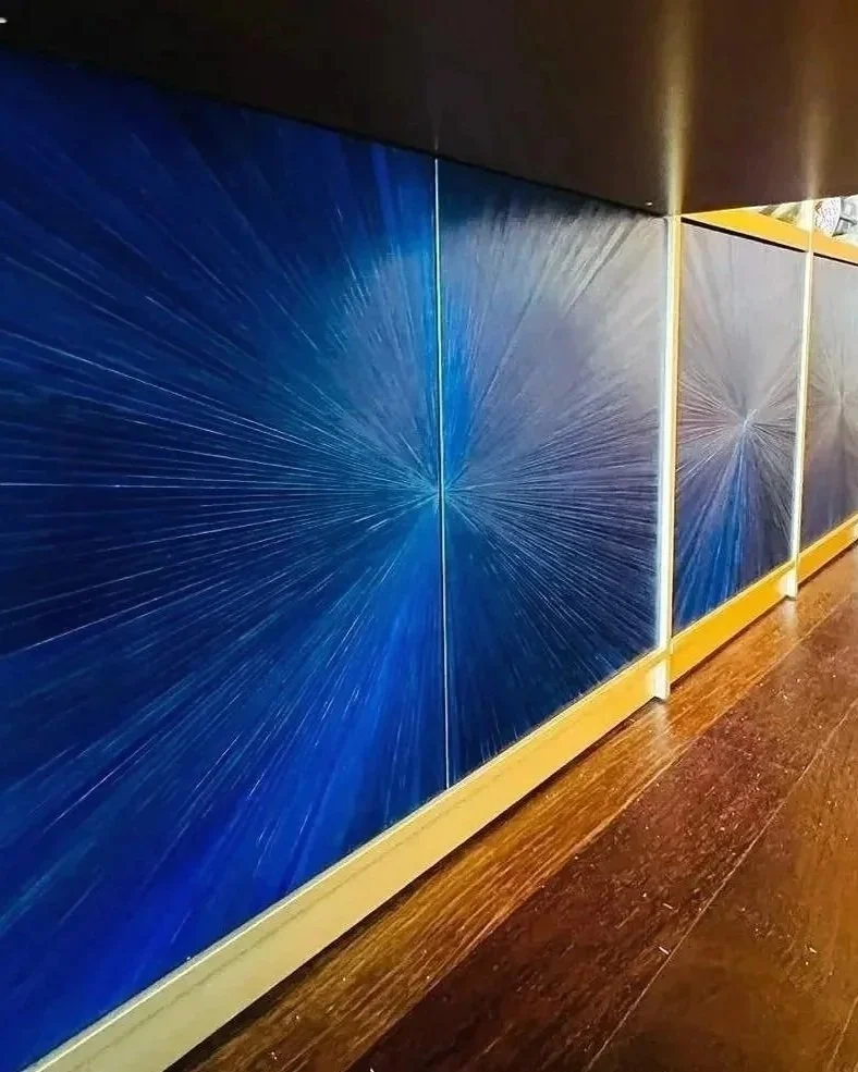 Mobili di colore blu con disegni lineari stellari, lungo un corridoio con pavimento in legno