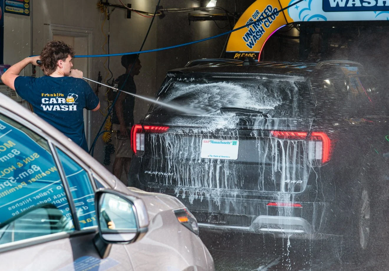 Employee washing a vehicle at The Franklin Car Wash