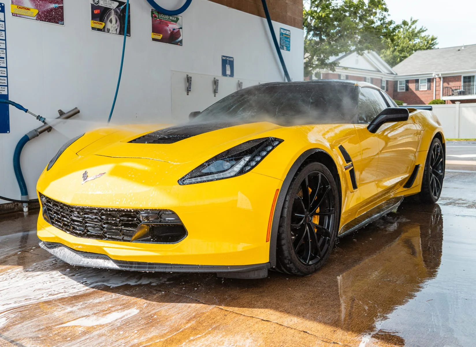 Yellow sports car in a self-service wash bay at The Franklin Car Wash