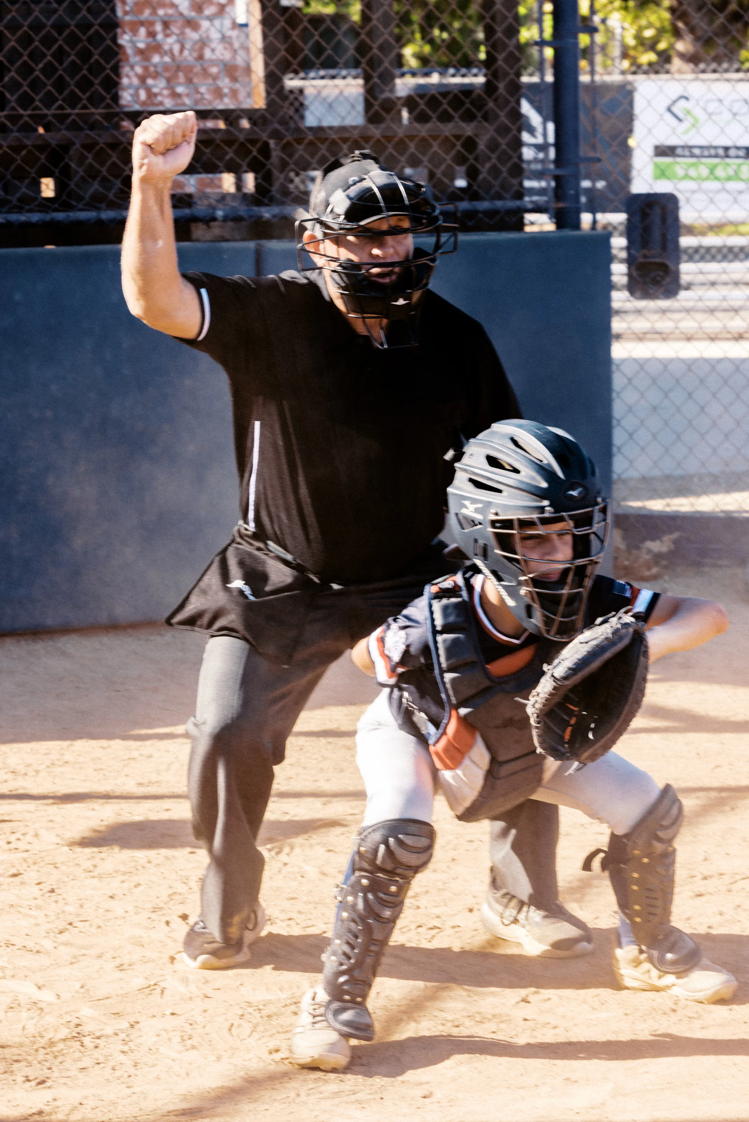 Jeff umpiring a little league game standing behind the catcher
