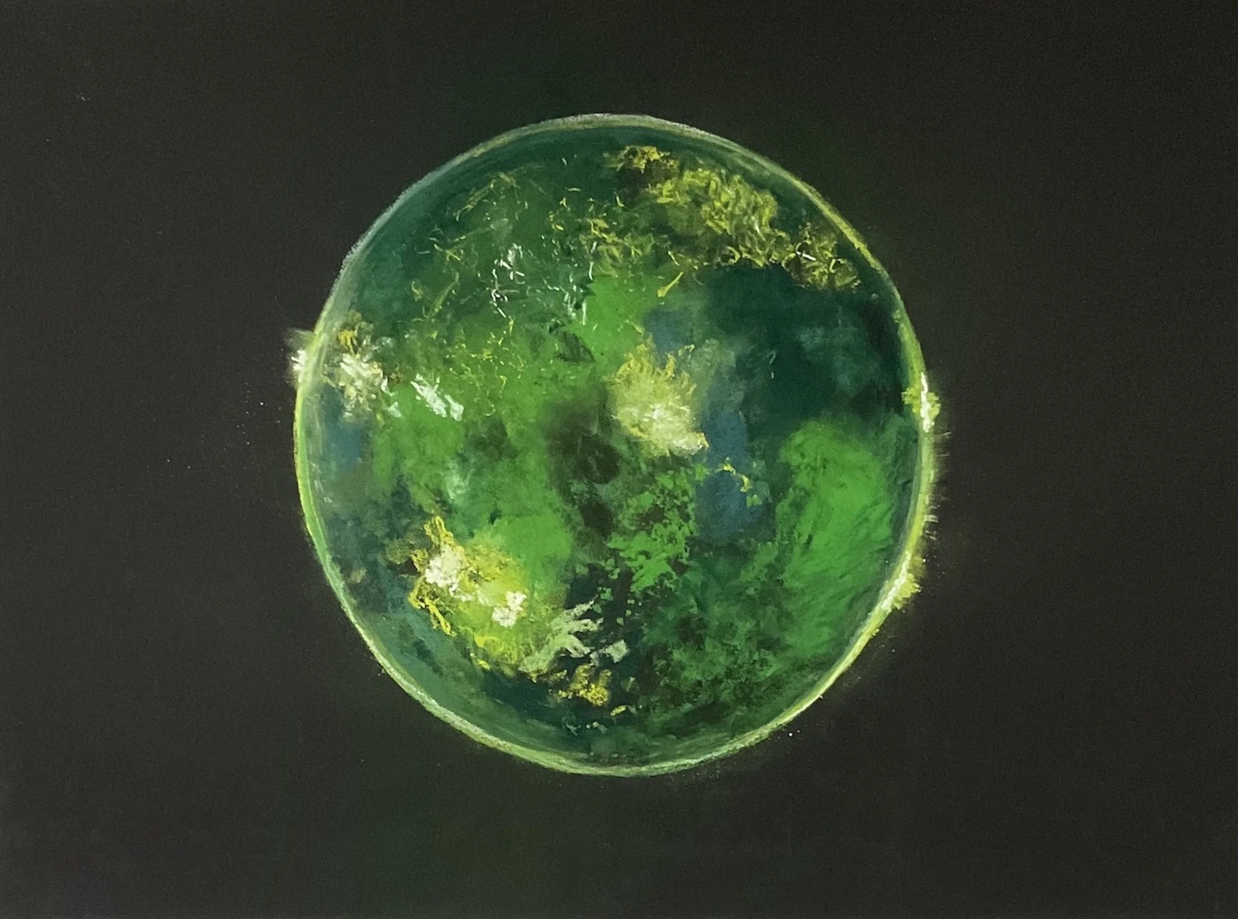 Close-up of a green marble with yellow and black swirls, set against a dark background.