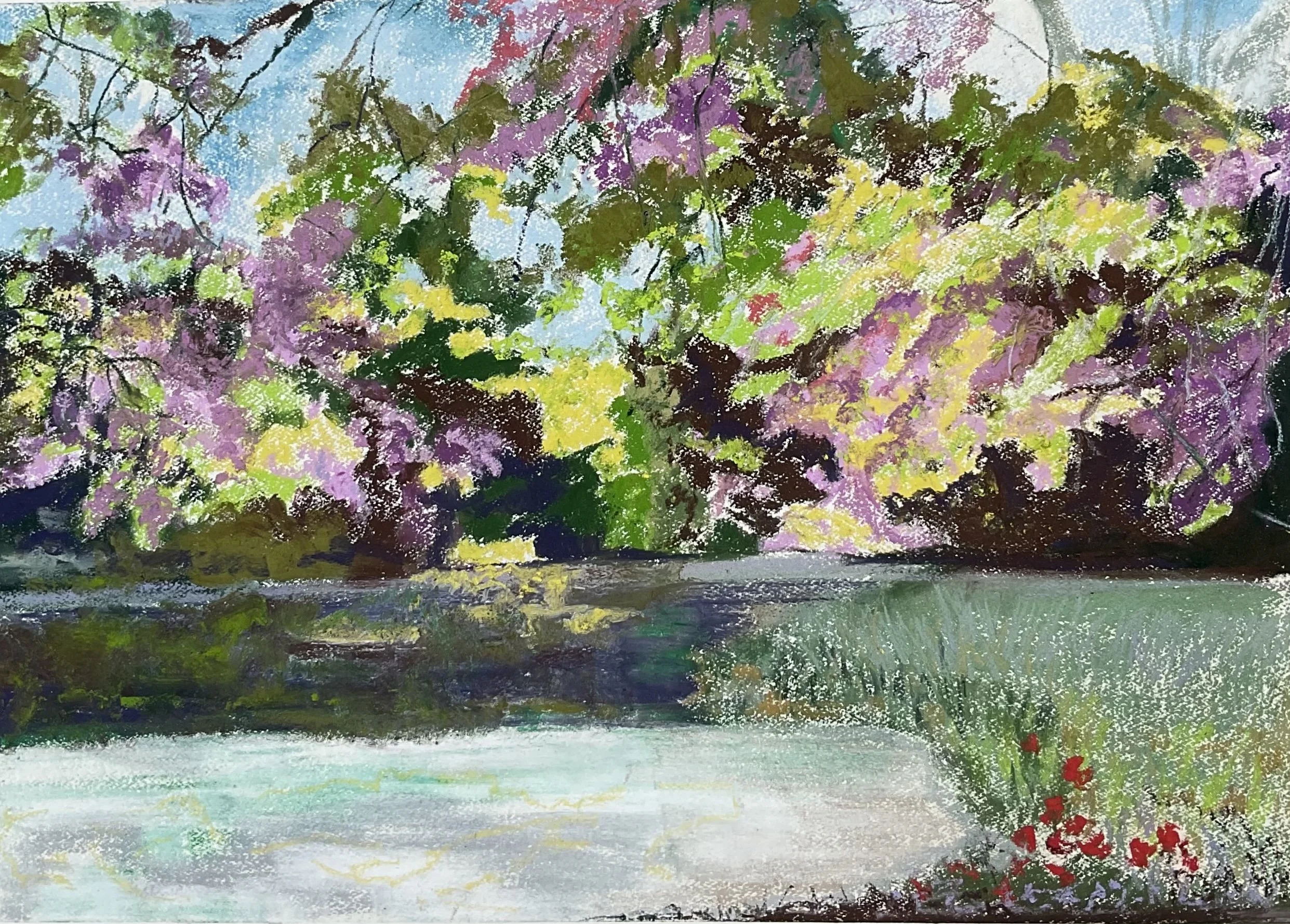An impressionistic painting of a garden scene featuring a tree with pink and purple blossoms, green foliage, and a blue sky in the background, with a body of water and some red flowers in the foreground.