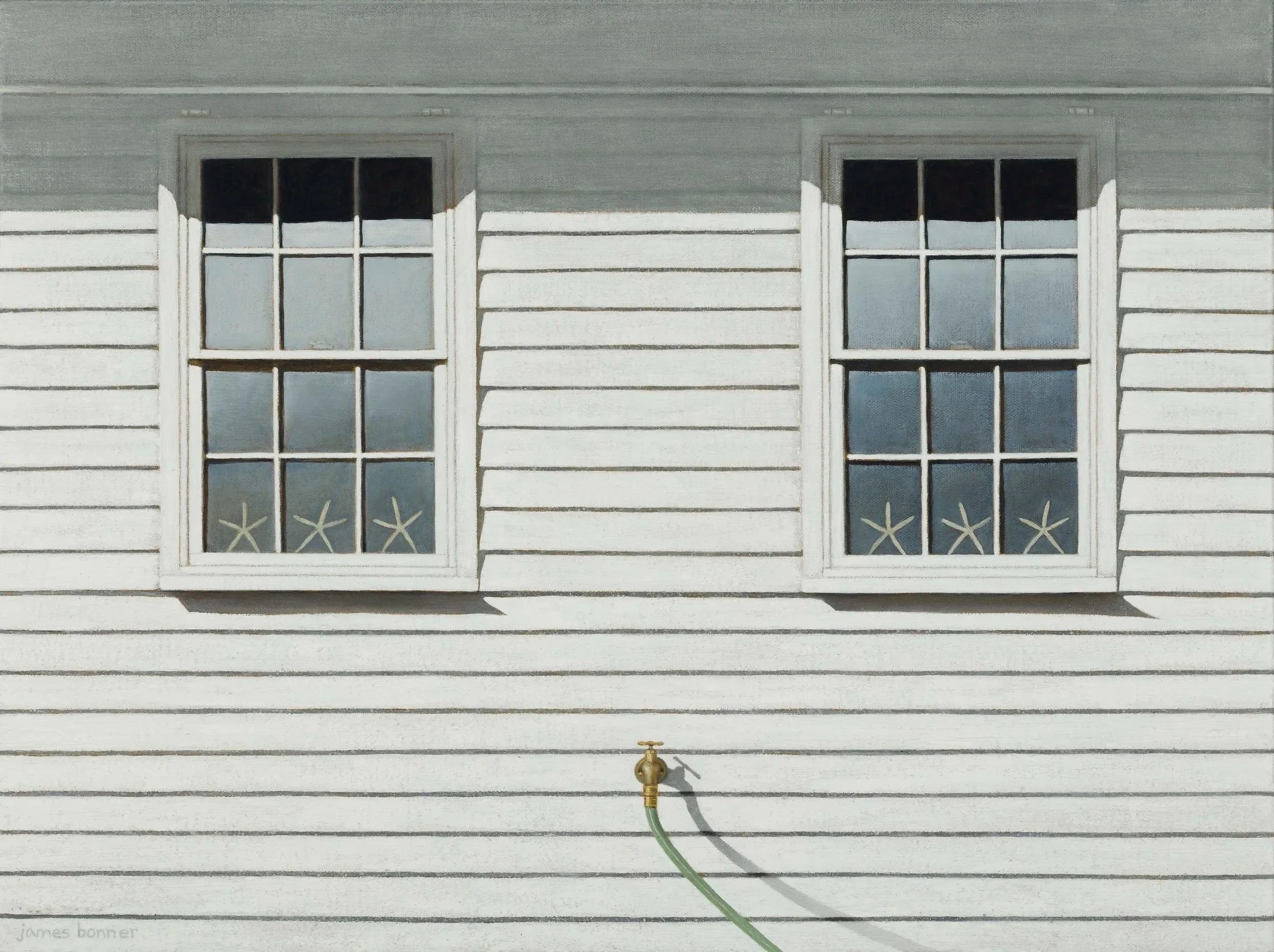 The image shows the exterior of a house with horizontal white wooden siding, two windows with white frames, and black mullions. There is a brass outdoor faucet below the windows with a green hose attached. The house has a gray roof with white trim.