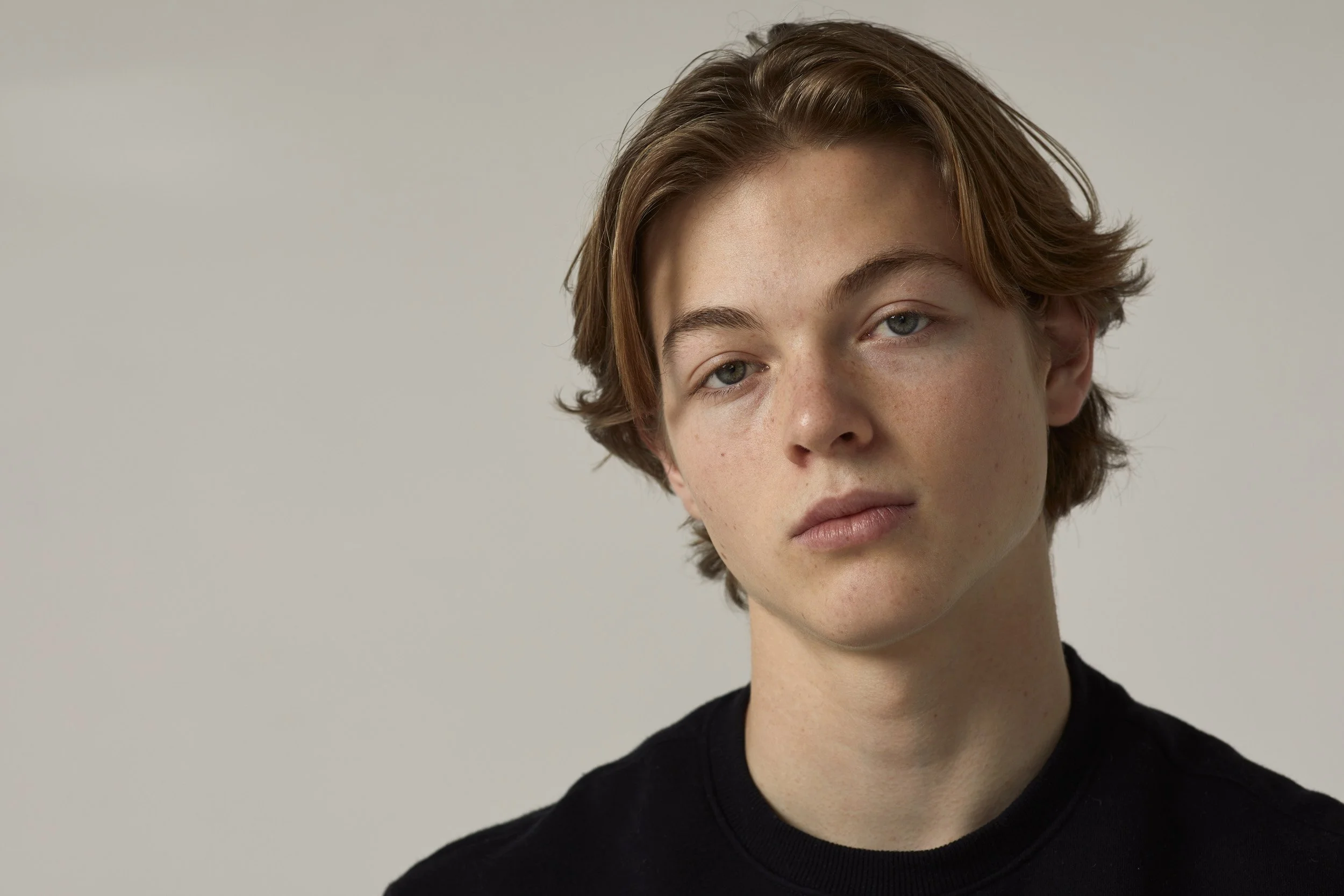 Young person with medium-length hair and a neutral expression
