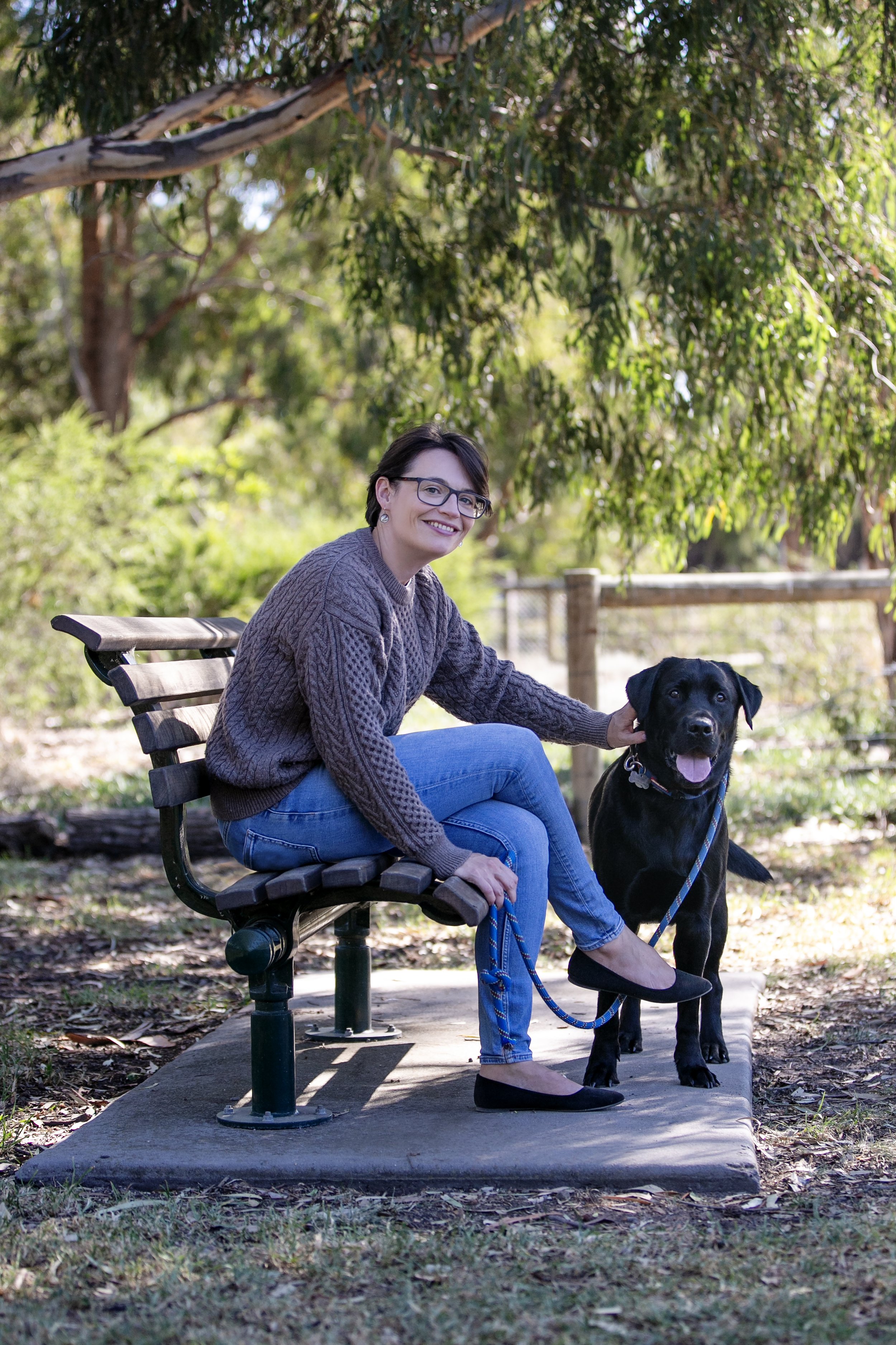 A veterinary oncologist in the outdoors with her Labrador.