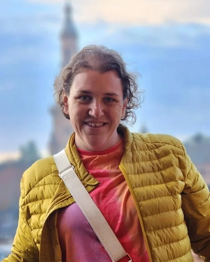 Close-up of Bec Swillen, founder of Run Recruitment. She is wearing a yellow jacket and a pink tie-dye shirt. Expert in writing professional resumes and an experienced recruiter.