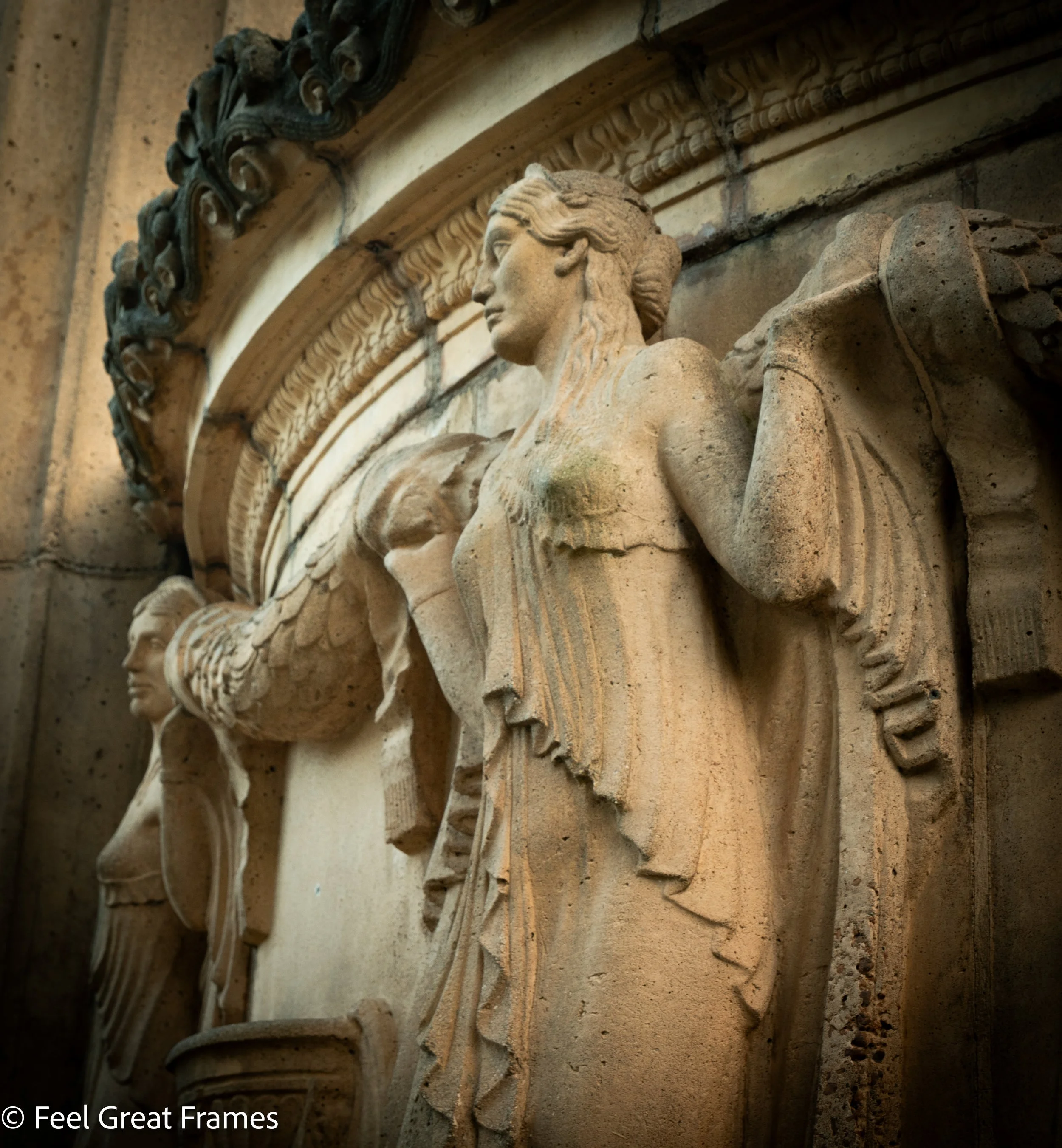Close-up view of ancient stone architectural carvings, featuring a woman's profile with flowing hair, part of a decorative frieze with intricate details, possibly part of a historic cathedral or monument.