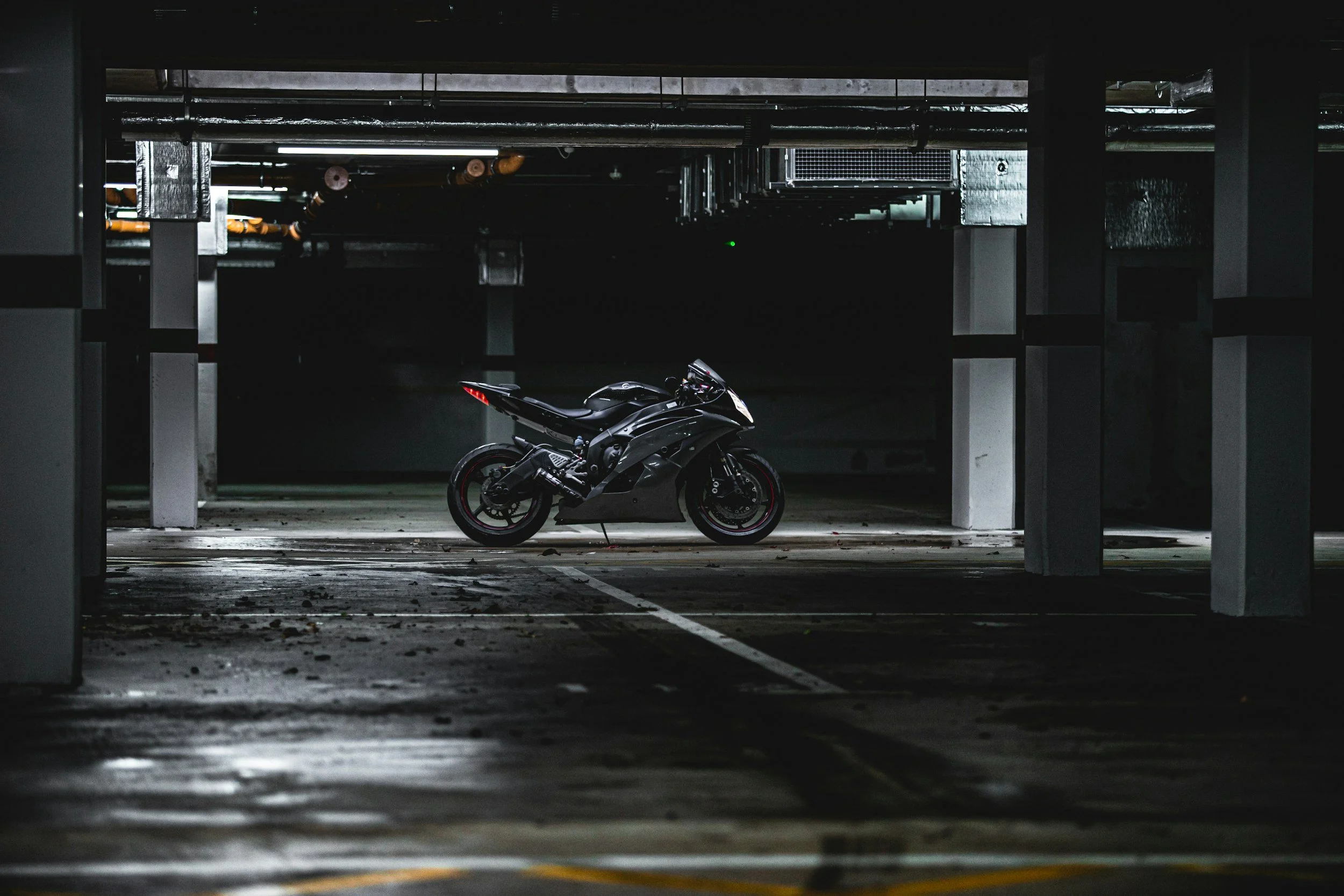 Moto negra estacionada en un espacio oscuro de estacionamiento subterráneo