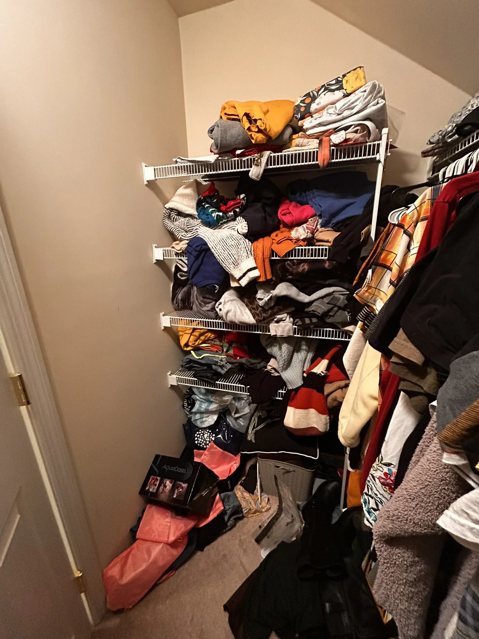A closet with wire shelves filled with clothes, shoes, and bags, with various items overlapping and hanging over the edges.